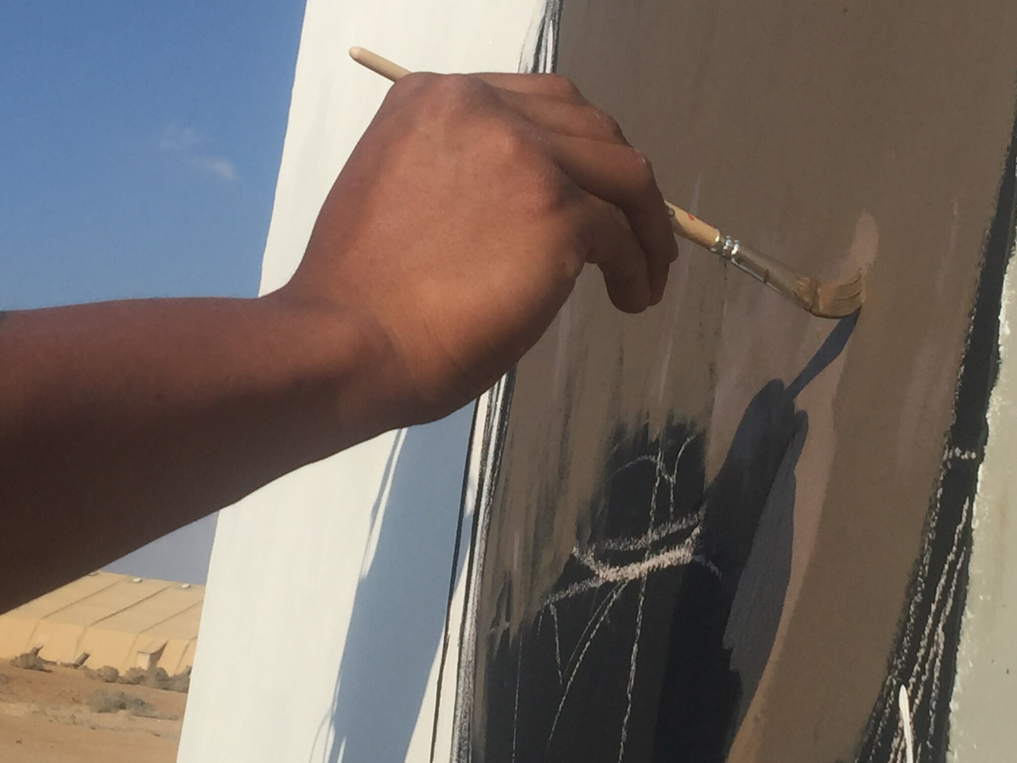 Staff Sgt. Joshua Martinez, 332nd Expeditionary Aircraft Maintenance Unit crew chief, paints a mural in honor of the Tuskegee Airmen April 6, 2018, at an undisclosed location in Southwest Asia.