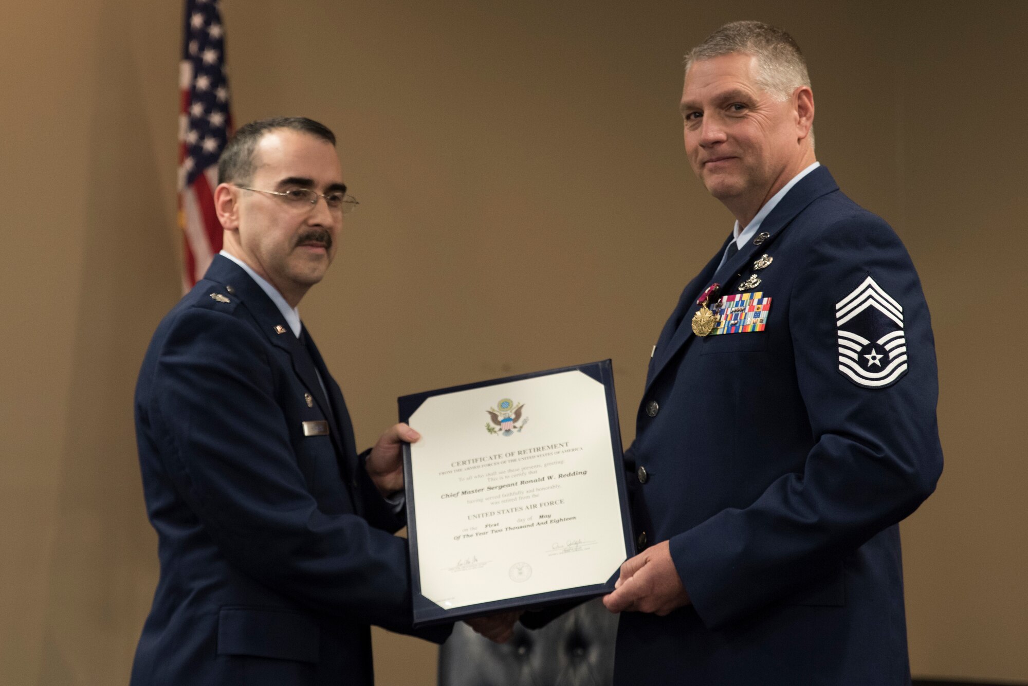 Lt. Col Micheal D. Howard, 188th Civil Engineering Commander, presents Cheif Master Sgt. Ronald W. Redding,188th Civil Engineering Squadron Emergency Management Chief, with the Certificate of Retirement during Cheif Redding's retirement ceremony at Fort Smith, AR., Apr. 07, 2018. (U.S. Air National Guard photo by Tech. Sgt. Daniel Condit)