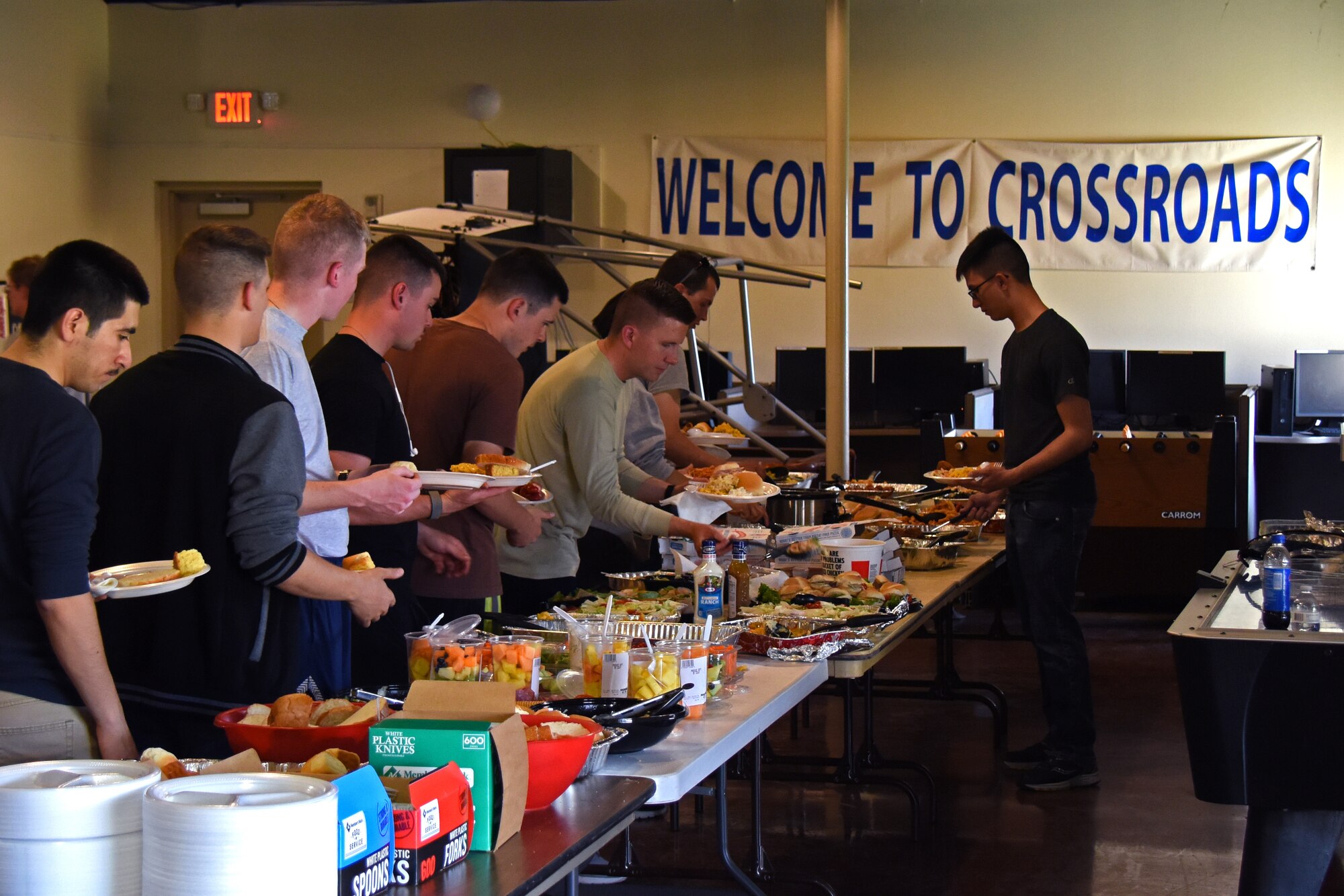 Trainees make their way down the buffet of food provided by the Top 3 and permanent party members during the Top 3 Dorm Dinner at the Crossroads on Goodfellow Air Force Base, Texas, April 5, 2018. The Crossroads offers many events like this for trainees so they can have a place where they can socialize and relax. (U.S. Air Force photo by Airman 1st Class Zachary Chapman)