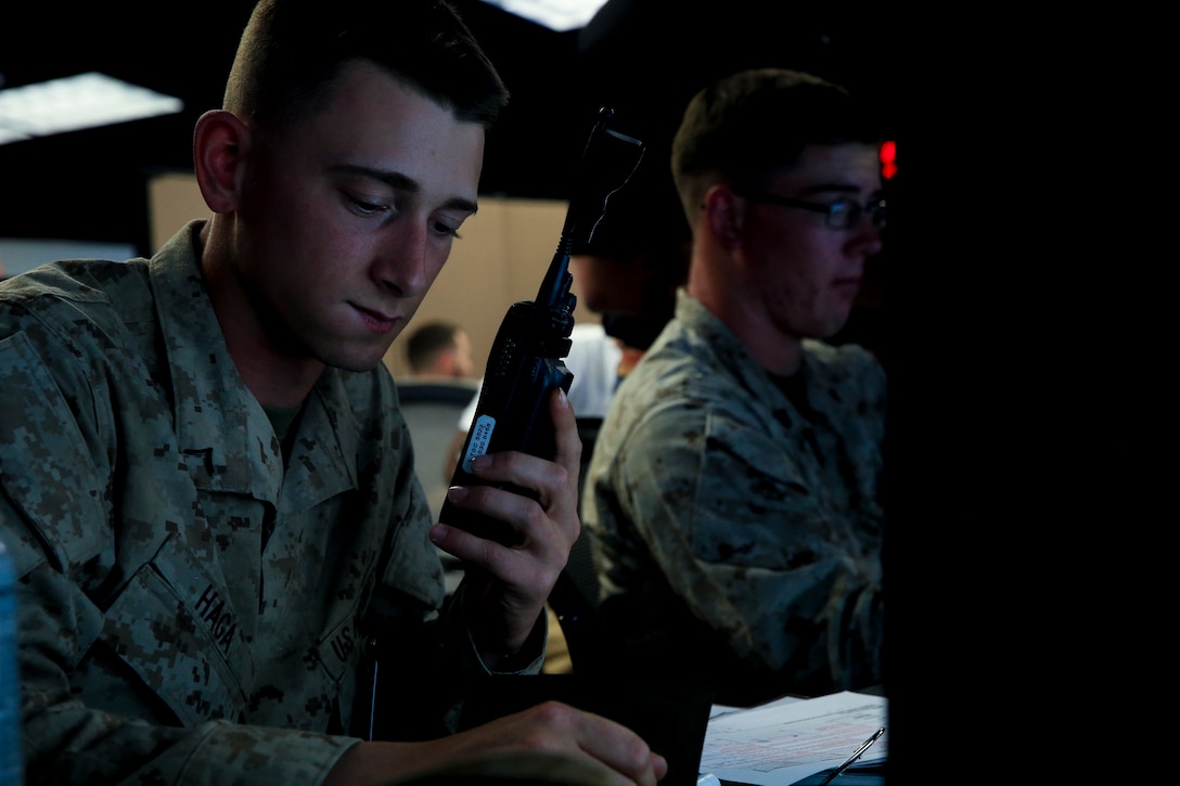 Pfc. Gage Haga, transmissions system operator, 1st Battalion, 4th Marine Regiment, stationed out of  Marine Corps Base Camp Pendleton, Calif., communicates with units acting as simulated casualties during Command Post Exercise 2 at the Battle Simulation Center aboard the Marine Corps Air Ground Combat Center, Twentynine Palms, Calif., March 29, 2018. CPX-2 is a  two-part training event that focuses on training battalion staff and is a part of TALONEX 2-18, a pre-deployment training event that coincides with Weapons and Tactics Instructors Course.  (U.S. Marine Corps photo by Lance Cpl. Isaac Cantrell)