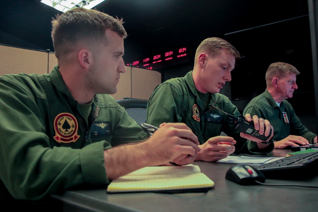 Capt. Theodore Linn (right), AH-1 pilot, Marine Light Attack Helicopter Squadron 267, and 1st Lt. Andrew Donohue (left), AH-1 pilot, HMLA-267, record the time during Command Post Exercise 2 at the Battle Simulation Center aboard the Marine Corps Air Ground Combat Center, Twentynine Palms, Calif., March 29, 2018. CPX-2 is a two-part training event that focuses on training battalion staff and is a part of TALONEX 2-18, a pre-deployment training event that coincides with Weapons and Tactics Instructors Course. (U.S. Marine Corps photo by Lance Cpl. Isaac Cantrell)