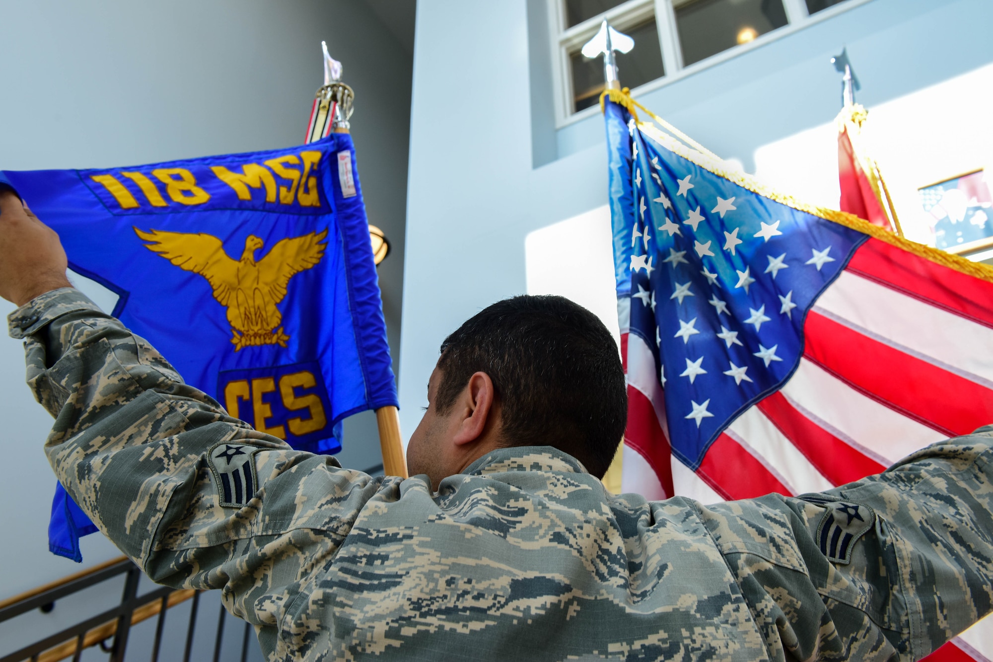 Senior Airman Mohammed Alzubaidi, an electrical systems specialist with the 118th Civil Engineer Squadron, poses with the flags of the United States and his unit on Sept. 27, 2017 at Berry Field Air National Guard Base in Nashville, Tennessee.