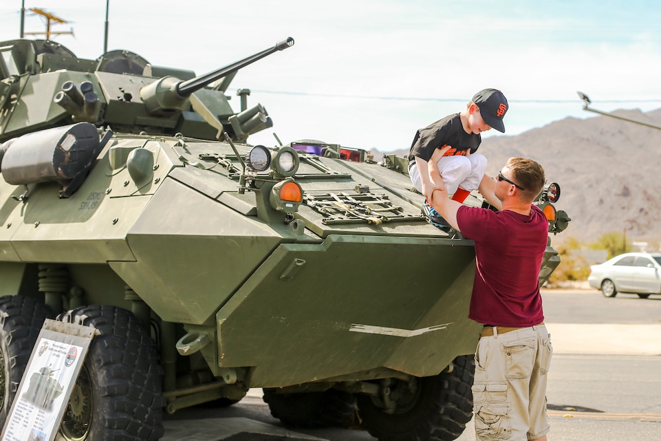 Sgt. Nathan J. Wepking, company master gunner, 3rd Light Armored Reconnaissance Battalion, lifts his son, Joshua Parker Wepking, off of a light armored vehicle during the 18th Annual Car Show and Street Fair, which was hosted by the Twentynine Palms Chamber of Commerce in Twentynine Palms, Calif., March 31, 2018.  The annual event is used to bring the community of Twentynine Palms and the Marine Corps Air Ground Combat Center, located in Twentynine Palms, together as well as support local businesses. (U.S. Marine Corps photo by Lance Cpl. Rachel K. Porter)