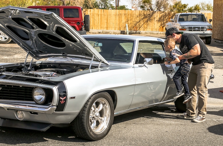 Robert McCabe, government contractor, Advancia Technology, shows his son the interior of a vehicle during the 18th Annual Car Show and Street Fair, which was hosted by the Twentynine Palms Chamber of Commerce in Twentynine Palms, Calif., March 31, 2018. The annual event is used to bring the community of Twentynine Palms and the Marine Corps Air Ground Combat Center, located in Twentynine Palms, together as well as support local businesses. (U.S. Marine Corps photo by Lance Cpl. Rachel K. Porter)