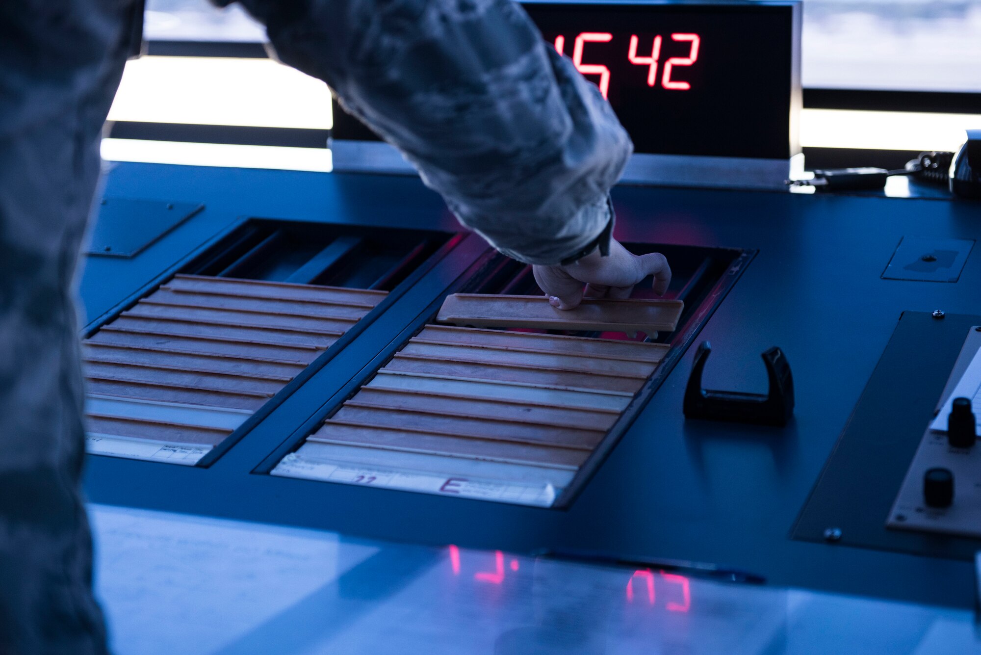 A U.S. Airman places down a “bone” on a desk in the air traffic control tower at Shaw Air Force Base, S.C., April 5, 2018.