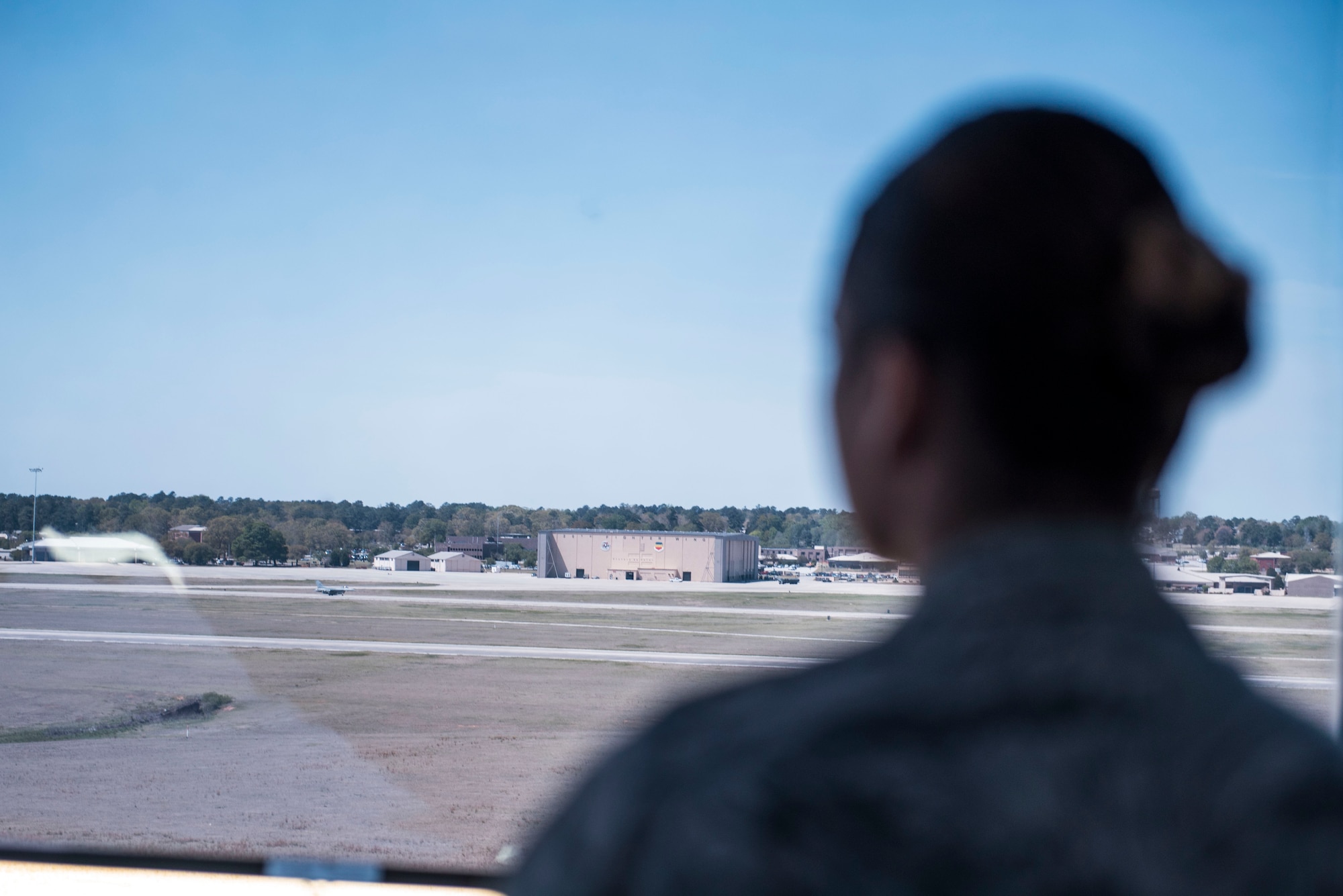 A U.S. Airman assigned to the 20th Operations Support Squadron air traffic control tower watches an F-16CM Fighting Falcon taxi down the runway at Shaw Air Force Base, S.C., April 5, 2018.