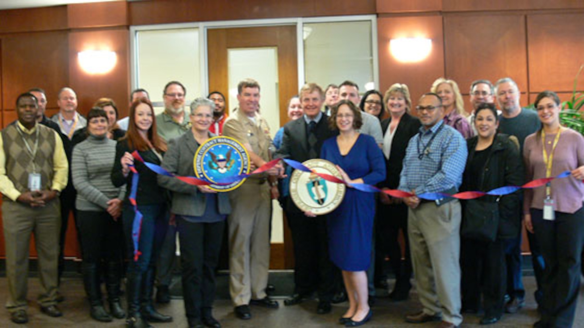 Navy Capt. Edward Zawislak (center), former Defense Contract Management Agency Baltimore commander, cuts the ribbon at the new satellite location in White Marsh, Maryland, on Feb. 23. Defense Contract Audit Agency personnel also work at the site. Representatives from both agencies attended the ribbon-cutting ceremony. (Photo courtesy of DCMA Baltimore)