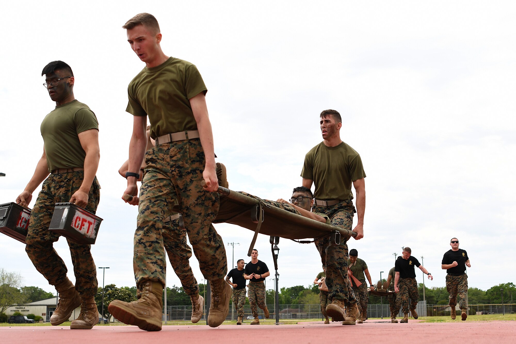 Members of the Keesler Marine Detachment participate in a timed casualty evacuation race during the 2nd Annual Warrior Day at the Triangle Track at Keesler Air Force Base, Mississippi, April 6, 2018. The race included carrying a team member on a stretcher, transporting ammo cans and water jugs. The event served to promote unit cohesion, camaraderie and small unit leadership. (U.S. Air Force photo by Airman 1st Class Suzie Plotnikov)