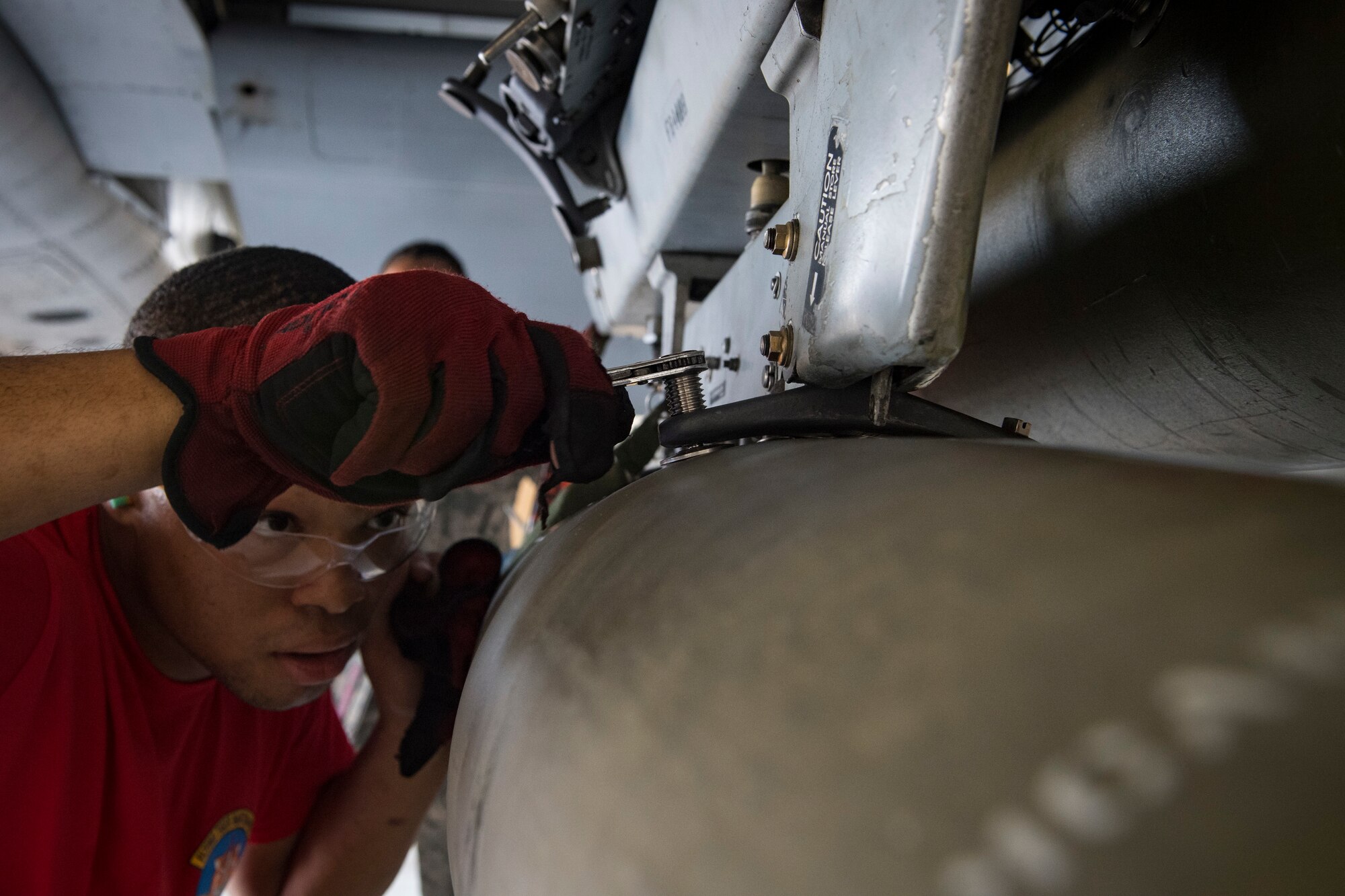 Airman 1st Class Maleek Hurd, 75th Aircraft Maintenance Unit weapons load crew member, secures an inert munition on an A-10C Thunderbolt II during a weapons load competition, April 9, 2018, at Moody Air Force Base, Ga. The 75th and 74th AMUs went head to head with each crew competing to load three munitions onto an A-10 quicker and with less discrepancies than the other. Crews were also judged on dress and appearance and a written test based on munitions knowledge. (U.S. Air Force photo by Senior Airman Janiqua P. Robinson)