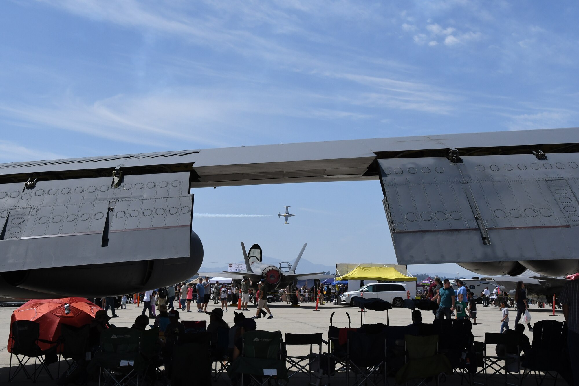 An aerial performer speeds past the crouds and static dispalys of aircraft during the March Field 2018 Air and Space Expo April 8, 2018.