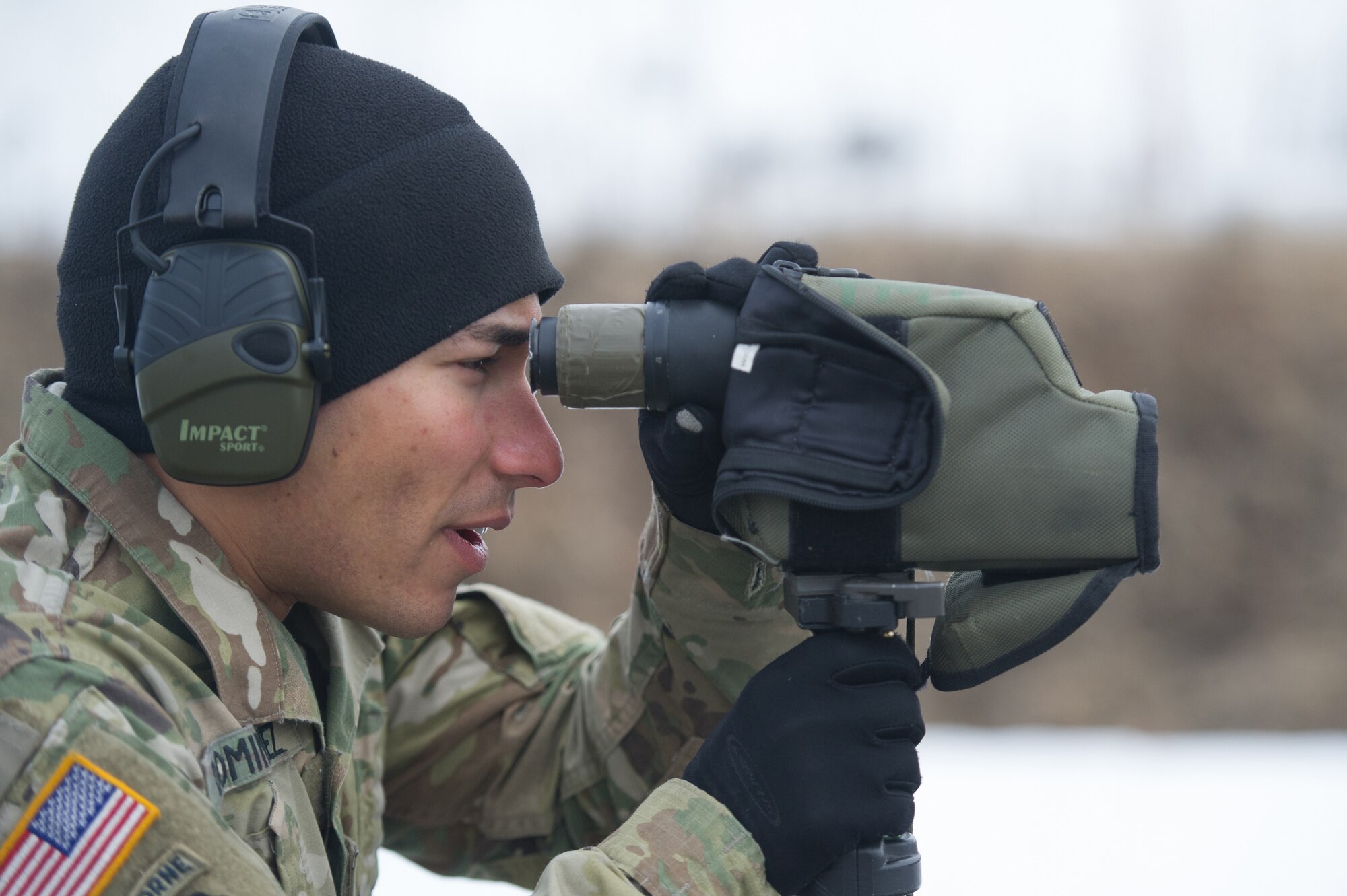 Army Spc. Arturo Dominguez, a native of Okeechobee, Fla., assigned to Charlie Troop, 1st Squadron, 40th Cavalry Regiment (Airborne), 4th Infantry Brigade Combat Team (Airborne), 25th Infantry Division, U.S. Army Alaska, uses a spotting scope to observe a fellow soldier’s accuracy with a M2010 Enhanced Sniper Rifle on Statler range at Joint Base Elmendorf-Richardson, Alaska, April 6, 2018, during marksmanship training.  A sniper's main responsibility is to deliver discriminatory, highly accurate rifle fire against enemy targets that cannot be engaged successfully by the regular rifleman due to range, size, location, fleeting nature, or visibility.