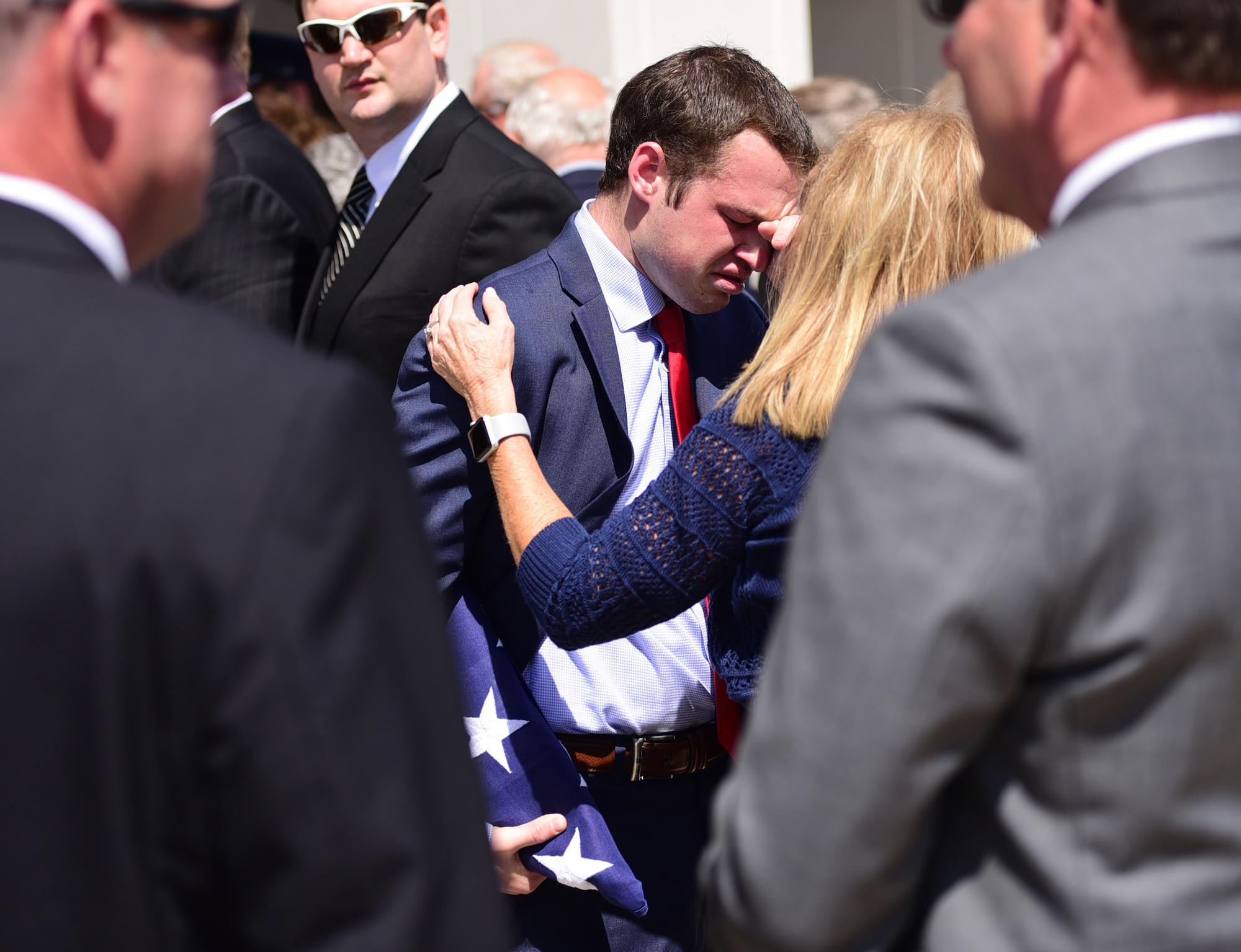 Matt Davis, grandson of Col. Edgar Davis embraces a family member after his grandfather’s funeral ceremony April 6, 2018, Goldsboro, North Carolina. After being shot down over Laos during the Vietnam War in 1968, a Laotian villager buried the remains. In 2015, the villager’s son reached out regarding the location of the remains. The Defense POW/MIA Accounting Agency recovered Davis’ remains in 2017. (U.S. Air Force photo by Senior Airman Christian Clausen)