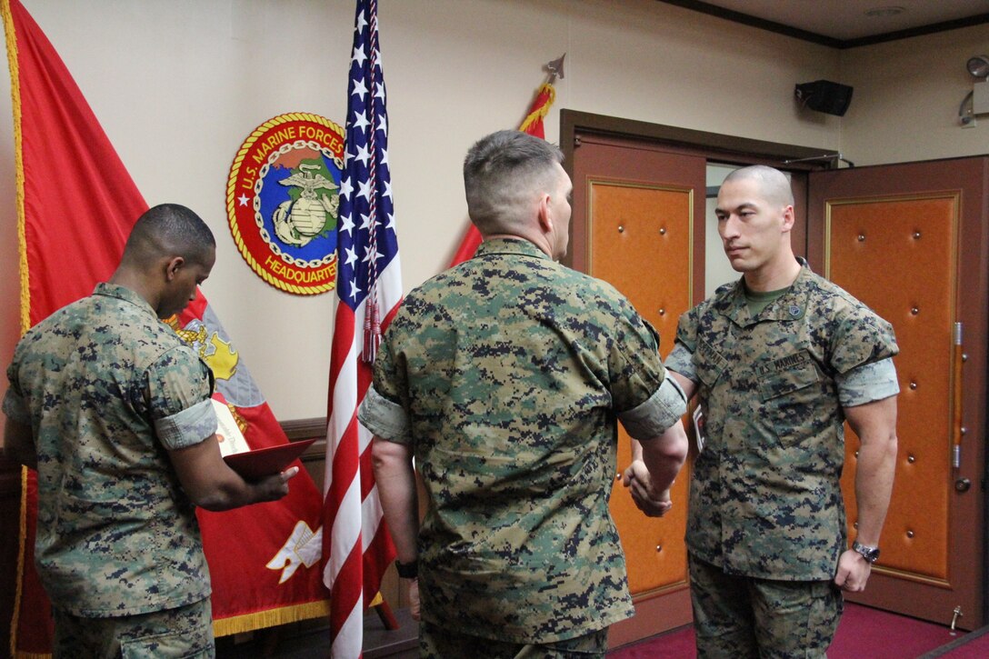 Lt. Col. Sidney R. Welch (Middle), assistant chief of staff for logistics, U.S. Marine Corps Forces Korea, congratulates Staff Sgt. Michael J. Hoffman, engineer chief, MARFORK, during his reenlistment ceremony here, April 6.  MARFORK celebrated Hoffman’s reenlistment and commitment to four more years in the Marine Corps.  Hoffman first enlisted in 2008. (Official U.S. Marine Corps photo by Sgt. Nathaniel Hanscom/Released)