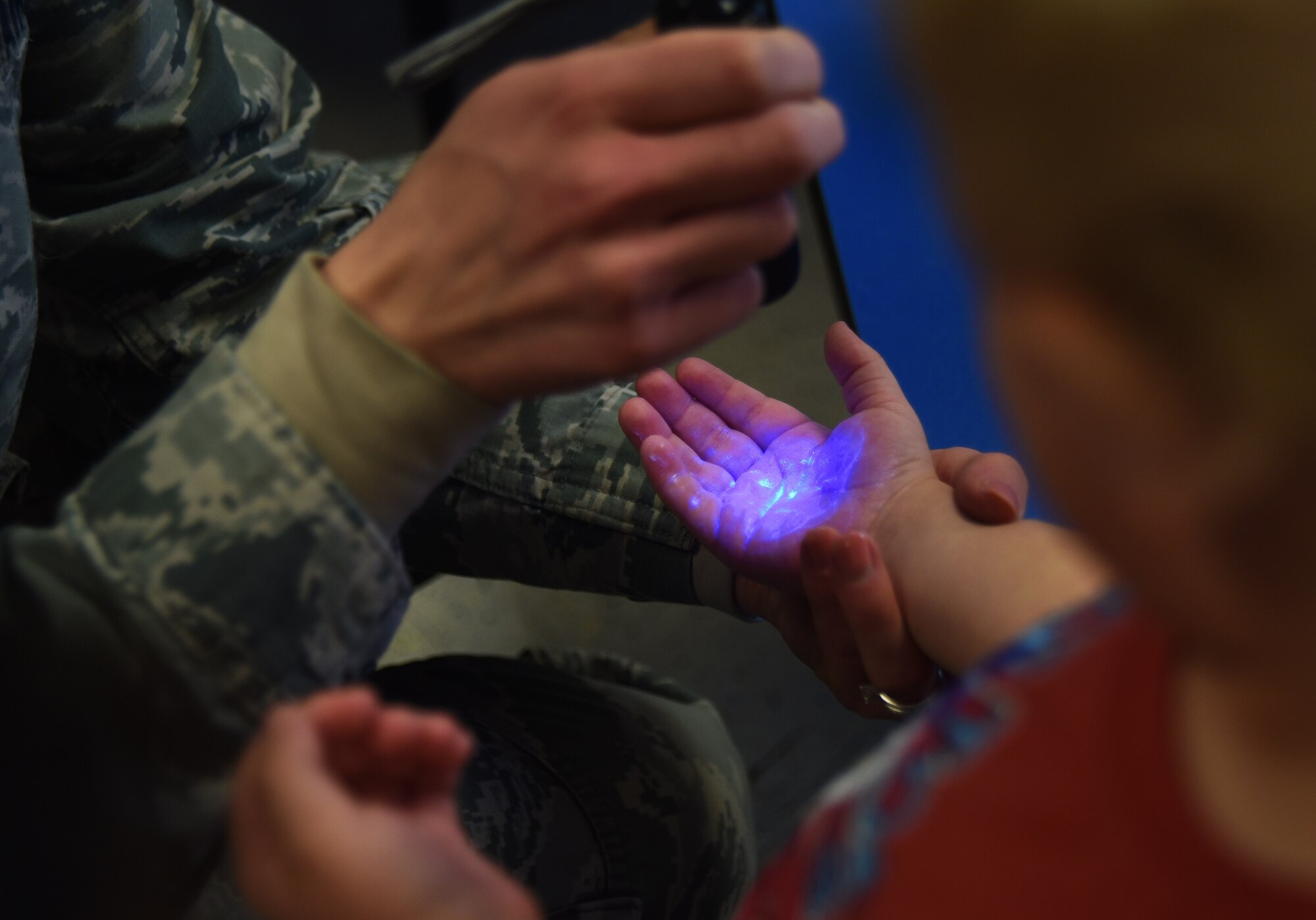 A toddler at the Child Development Center gets a “germ inspection” after washing her hands at McConnell Air Force Base, Kan., April 3, 2018. In honor of National Public Health Week, medical technicians instructed children how to properly wash their hands and prevent spreading germs. (U.S. Air Force photo by Amn Michaela R. Slanchik)