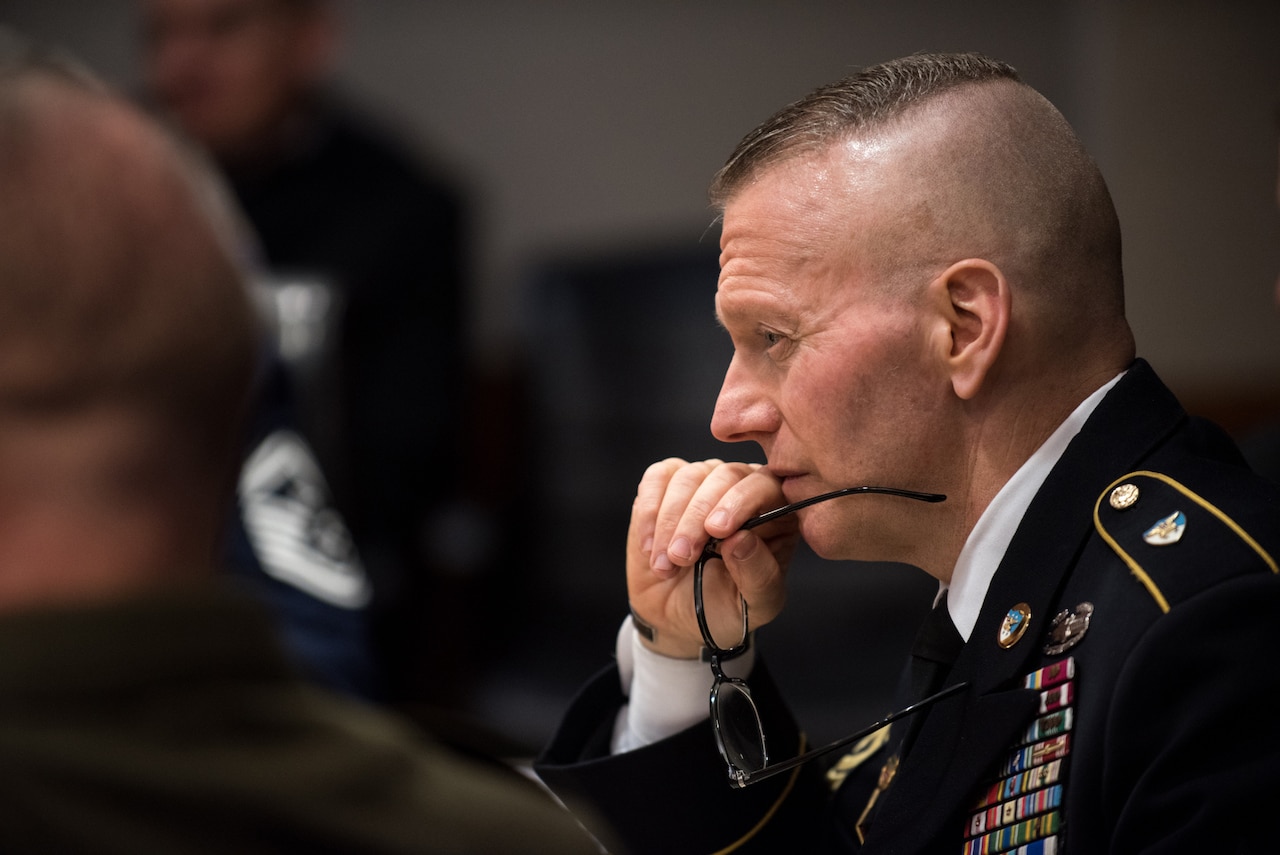 Army Command Sgt. Maj. John W. Troxell, shown in profile, sits with his glasses in his hand.