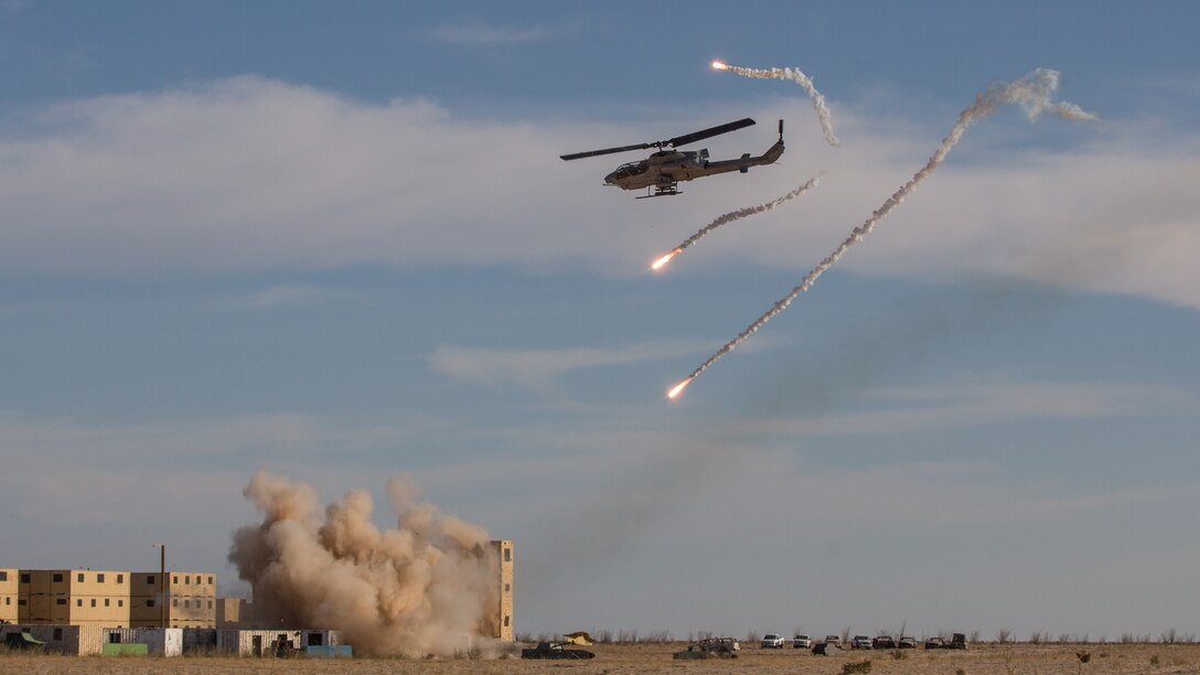 A U.S. Marine Corps AH-1W Super Cobra with Marine Aviation Weapons and Tactics Squadron 1 launches rockets at simulated enemy targets and deploys flares during a tactical demonstration in support of Weapons and Tactics Instructor course 2-18 at Yodaville, Yuma, Ariz., April 4.