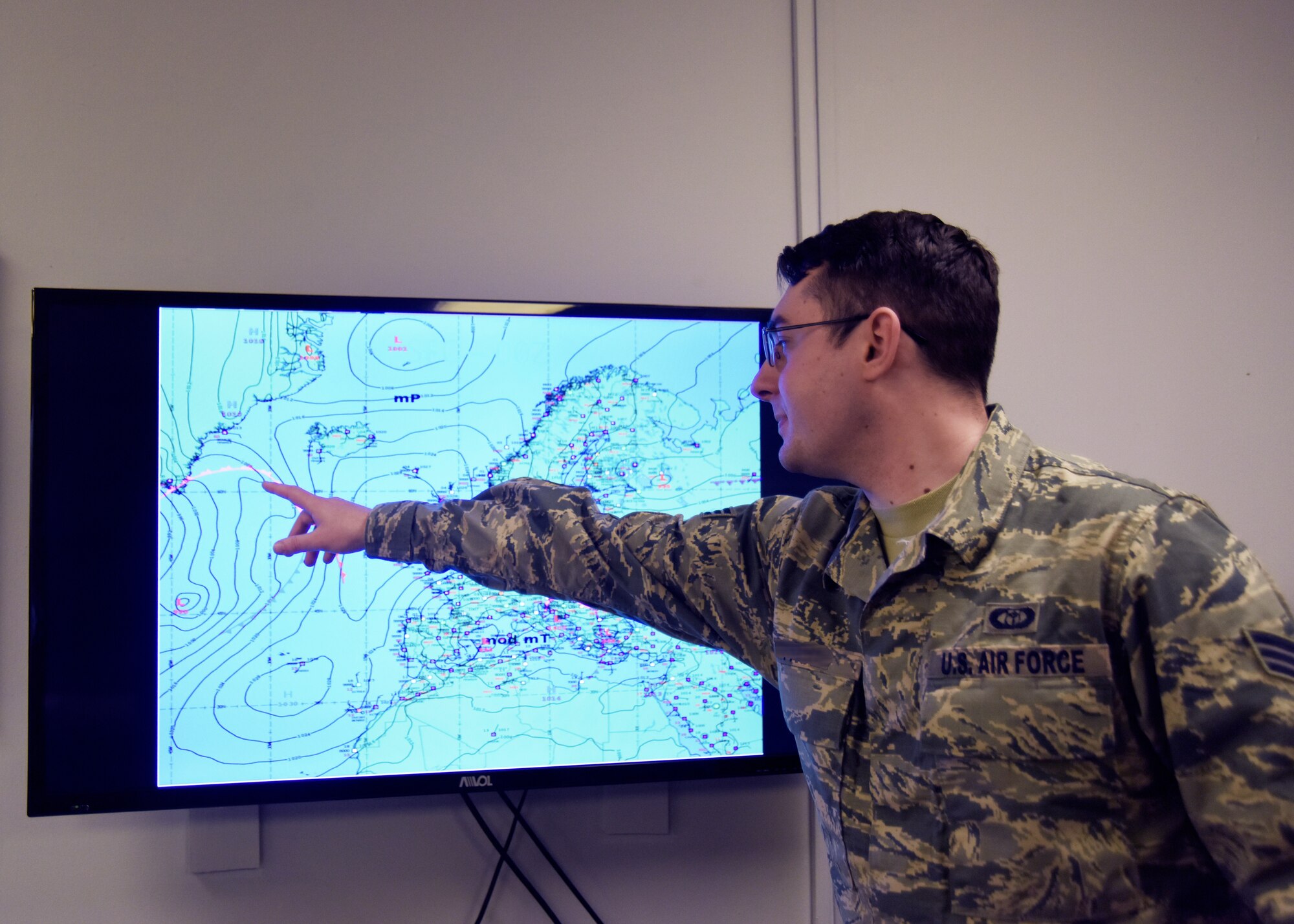 A 48th Operations Support Squadron weather forecaster journeyman displays a surface analysis map during the office morning weather briefing at Royal Air Force Lakenheath, England, March 20. Forecasters support aircrews by keeping them apprised of weather conditions, which allows them to focus on the Liberty Wing’s mission to provide responsive combat airpower and support. (U.S. Air Force photo/Senior Airman Abby L. Finkel)