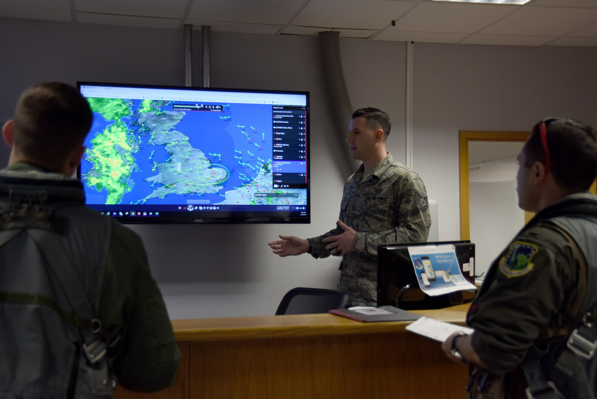 The 48th Operations Support Squadron mission integration function NCO in charge, center, briefs 494th Fighter Squadron pilots about the day’s weather before takeoff at Royal Air Force Lakenheath, England, March 20. Before each flight, pilots are briefed on the weather conditions including cloud coverage, visibility, and wind speed and direction, so that they know what to expect while they’re in the air and can plan accordingly. (U.S. Air Force photo/Senior Airman Abby L. Finkel)