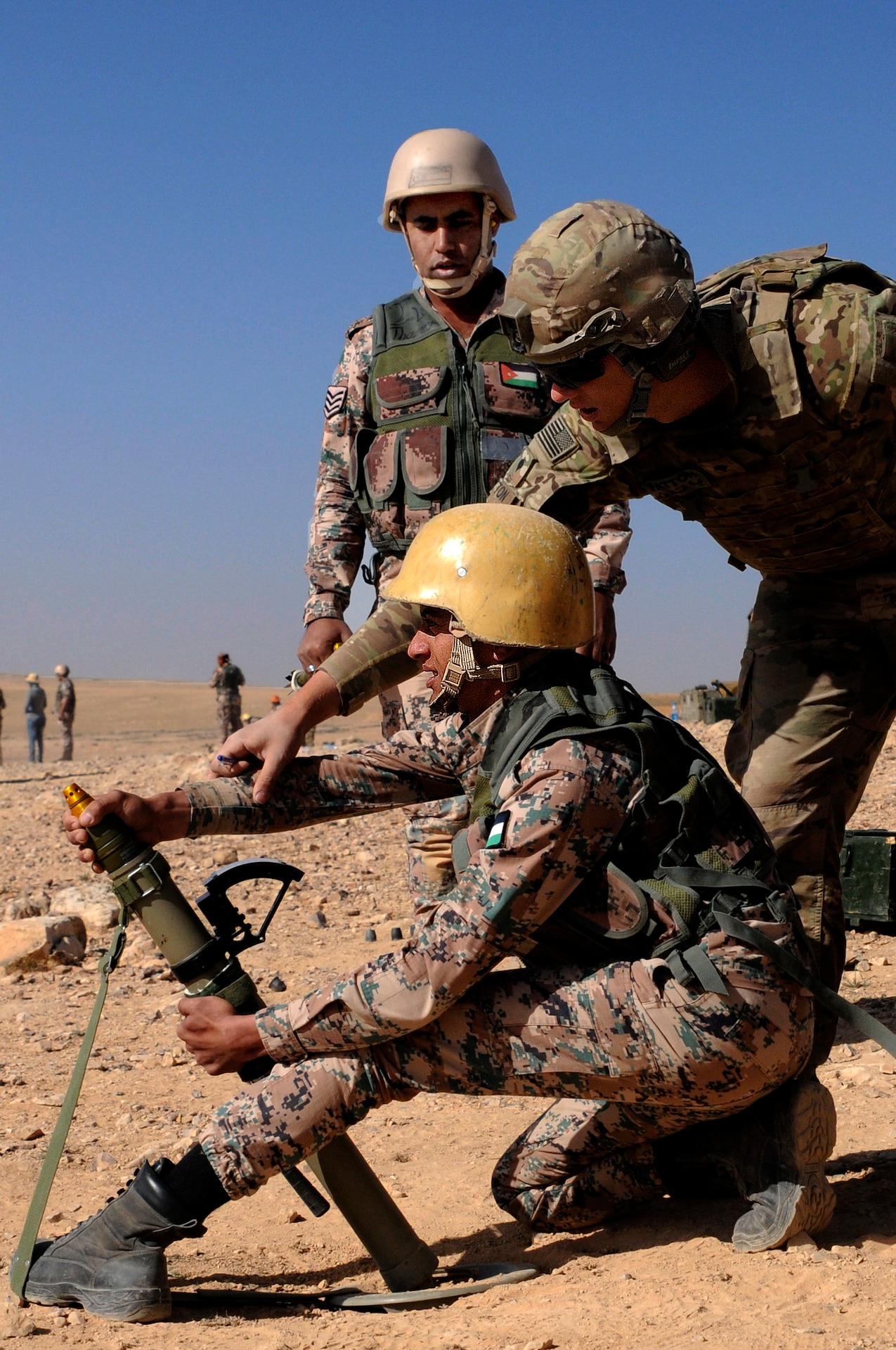 U.S. Army Spc. James Patton, an indirect fire infantryman, 1st Battalion, 184th Infantry Regiment, observes a Jordan Armed Forces 11th Border Security soldier during a 60 mm mortar live fire outside of Amman, Jordan, April 4, 2018.