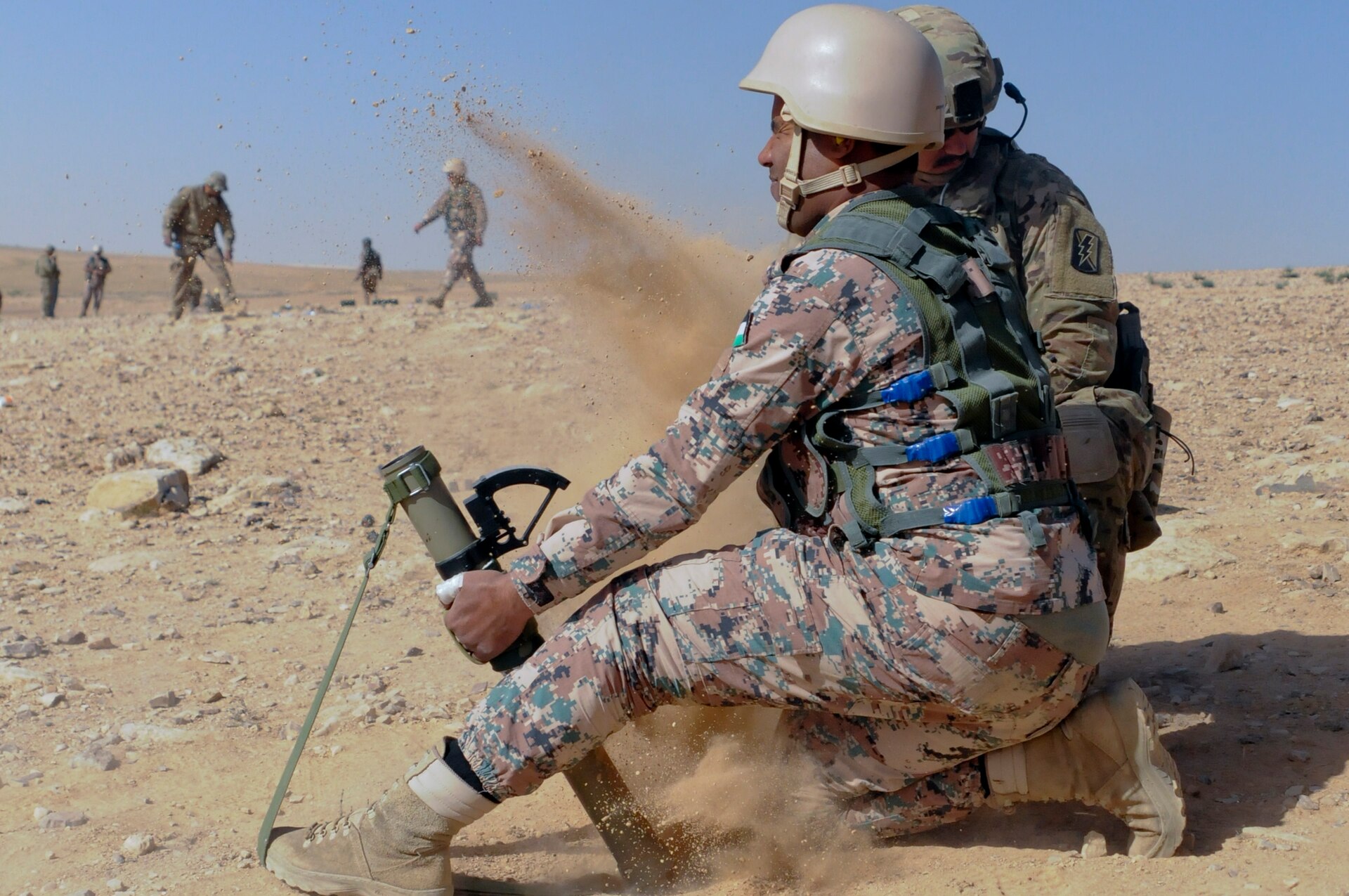 U.S. Army Spc. Bradley Wilkerson, an indirect fire infantryman, 1st Battalion, 184th Infantry Regiment, oberves a Jordan Armed Forces 11th Border Security soldier during a 60 mm mortar live fire outside of Amman, Jordan, April 4, 2018.