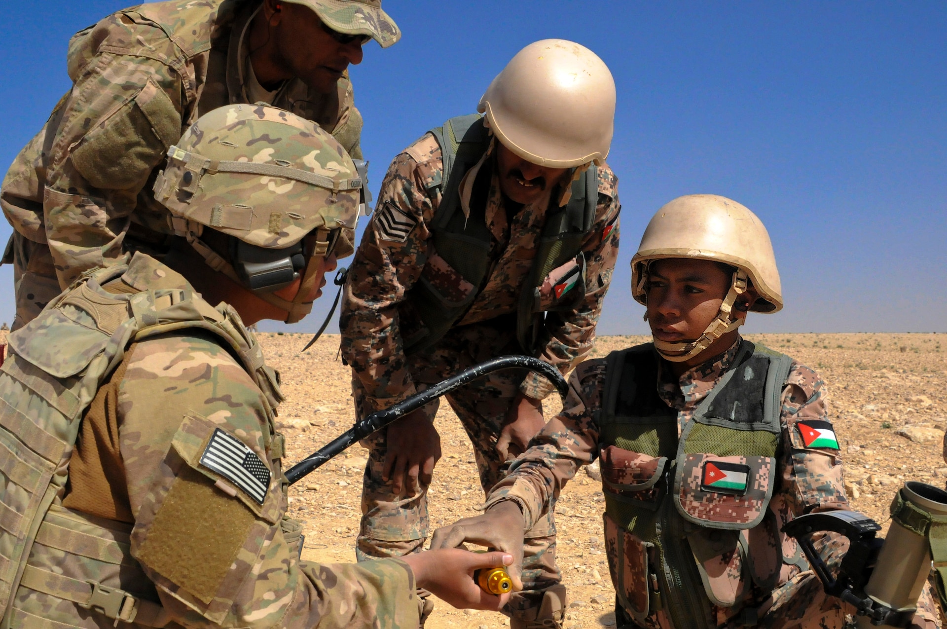 U.S. Army Spc. Mario Osorio, an indirect fire infantryman, 1st Battalion, 184th Infantry Regiment, hands a Jordan Armed Forces 11th Border Security soldier a mortar during a 60 mm mortar live fire outside of Amman, Jordan, April 4, 2018.