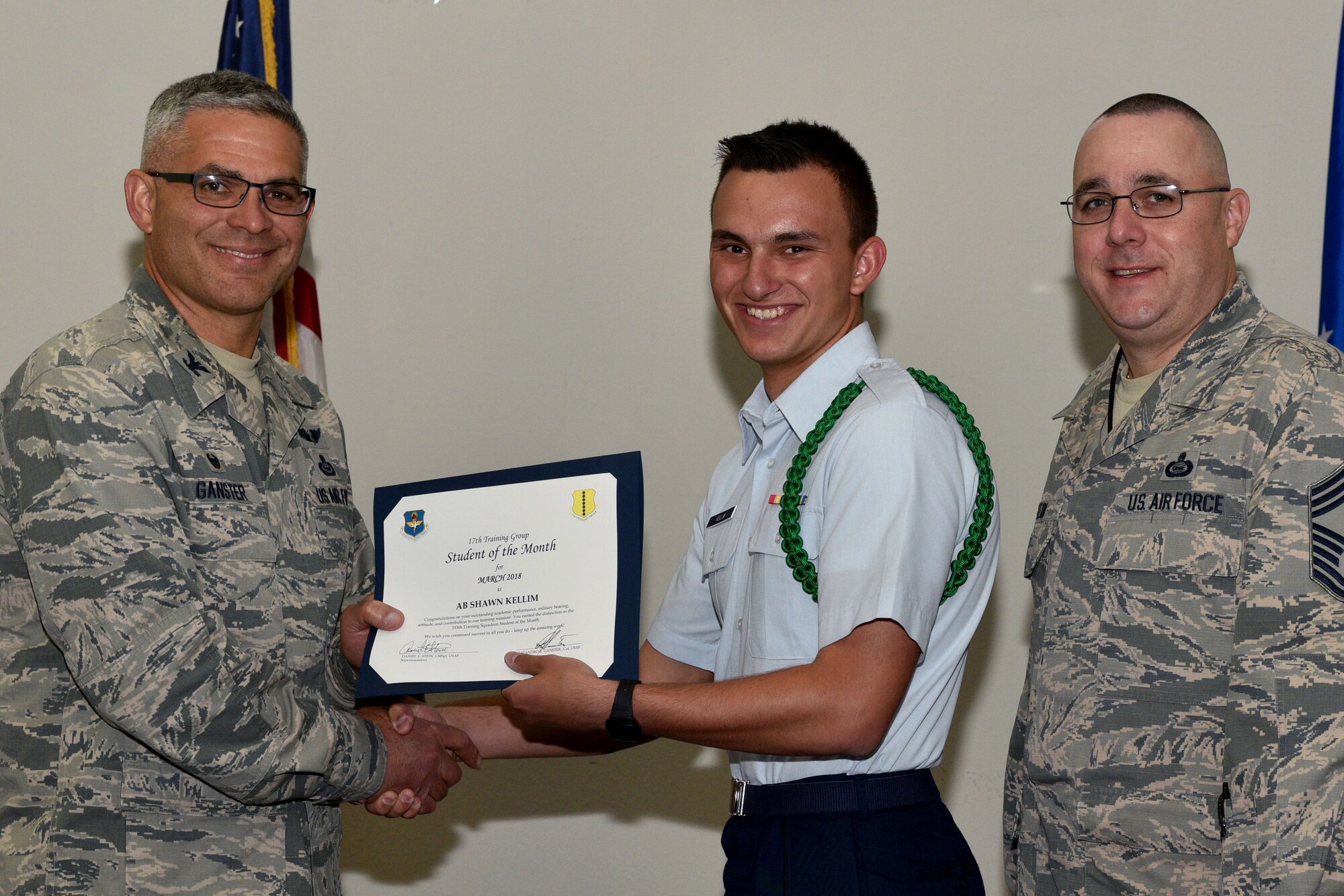 U.S. Air Force Col. Alex Ganster, 17th Training Group commander, and Chief Master Sgt. Daniel Stein, 17th TRG superintendent, present the 315th Training Squadron Student of the Month certificate to Airman Shawn Kellim, 315th TRS trainee, in the Event Center on Goodfellow Air Force Base, Texas, April 6, 2018. The 315th TRS’s vision is to develop combat-ready intelligence, surveillance and reconnaissance professionals and promote an innovative squadron culture and identity unmatched across the U.S. Air Force. (U.S. Air Force photo by Senior Airman Randall Moose/Released)