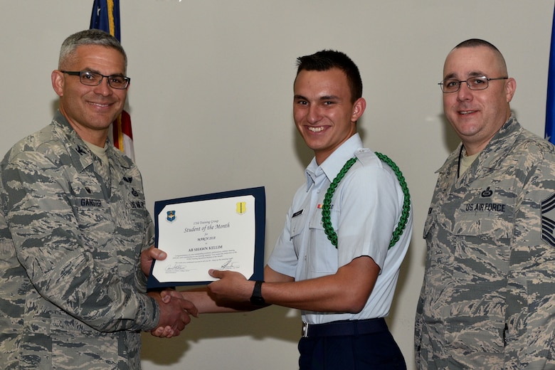 U.S. Air Force Col. Alex Ganster, 17th Training Group commander, and Chief Master Sgt. Daniel Stein, 17th TRG superintendent, present the 315th Training Squadron Student of the Month certificate to Airman Shawn Kellim, 315th TRS trainee, in the Event Center on Goodfellow Air Force Base, Texas, April 6, 2018. The 315th TRS’s vision is to develop combat-ready intelligence, surveillance and reconnaissance professionals and promote an innovative squadron culture and identity unmatched across the U.S. Air Force. (U.S. Air Force photo by Senior Airman Randall Moose/Released)