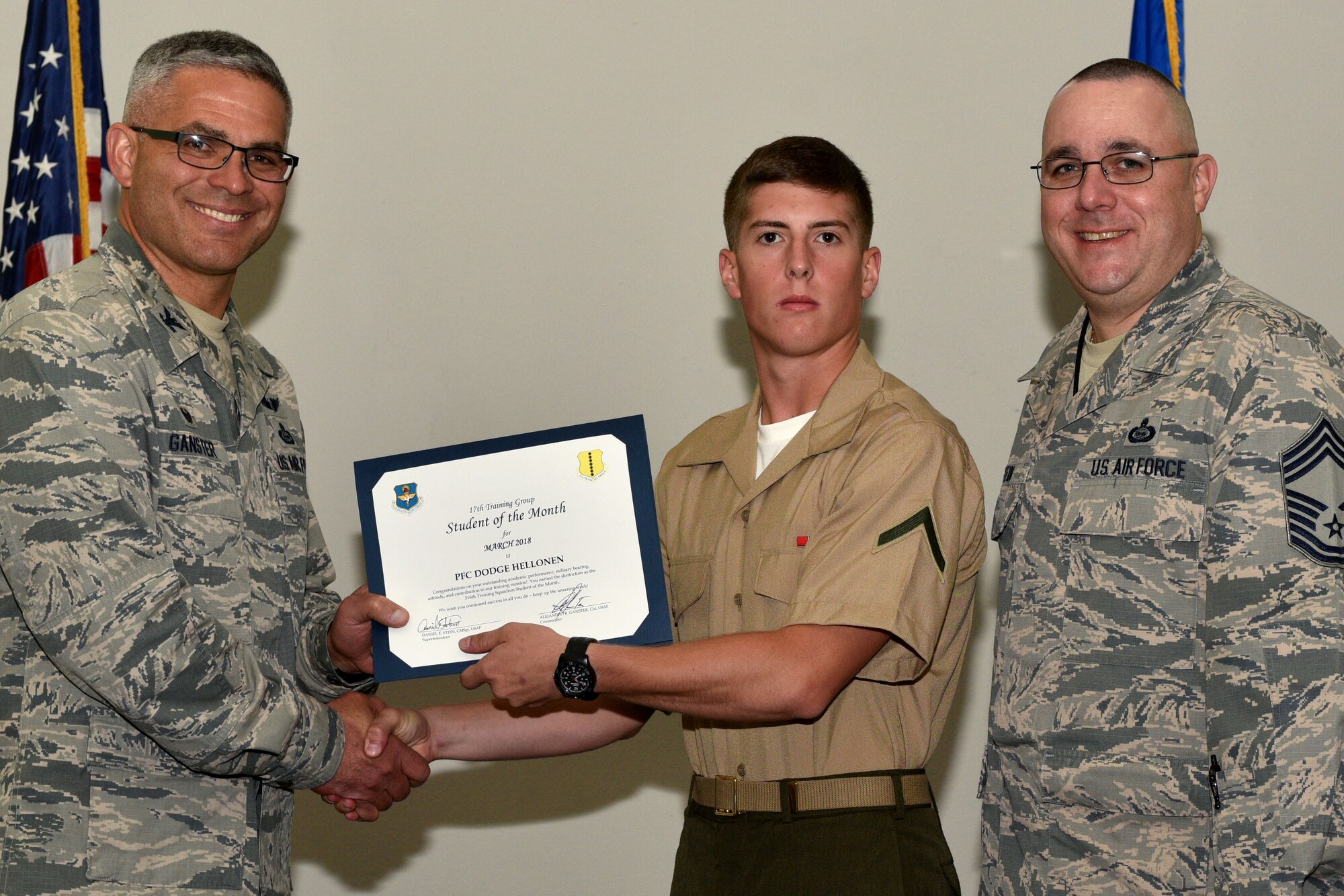 U.S. Air Force Col. Alex Ganster, 17th Training Group commander, and Chief Master Sgt. Daniel Stein, 17th TRG superintendent, present the 316th Training Squadron Student of the Month certificate to U.S. Marine Corps Pfc. Dodge Hellonen, 316th TRS trainee, in the Event Center on Goodfellow Air Force Base, Texas, April 6, 2018. The 316th TRS’s mission is to conduct U.S. Air Force, U.S. Army, U.S. Marine Corps, U.S. Navy and U.S. Coast Guard cryptologic, human intelligence and military training. (U.S. Air Force photo by Senior Airman Randall Moose/Released)