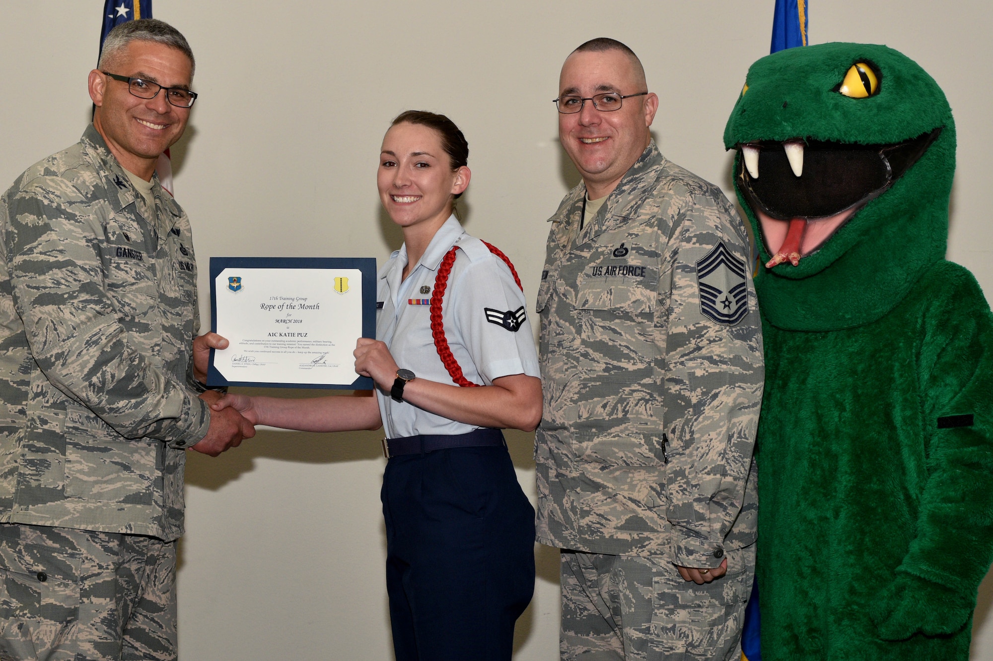 U.S. Air Force Col. Alex Ganster, 17th Training Group commander, and Chief Master Sgt. Daniel Stein, 17th TRG superintendent, present the 17th TRG Rope of the Month certificate to Airman 1st Class Katie Puz, 315th Training Squadron trainee, in the Event Center on Goodfellow Air Force Base, Texas, April 6, 2018. The mission of the 17th TRG is to train, develop and inspire professional fire protection and intelligence, surveillance and reconnaissance warriors. (U.S. Air Force photo by Senior Airman Randall Moose/Released)