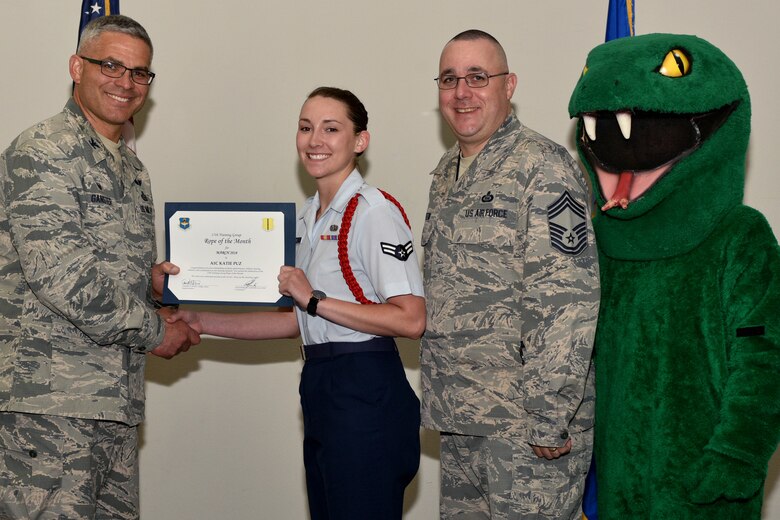 U.S. Air Force Col. Alex Ganster, 17th Training Group commander, and Chief Master Sgt. Daniel Stein, 17th TRG superintendent, present the 17th TRG Rope of the Month certificate to Airman 1st Class Katie Puz, 315th Training Squadron trainee, in the Event Center on Goodfellow Air Force Base, Texas, April 6, 2018. The mission of the 17th TRG is to train, develop and inspire professional fire protection and intelligence, surveillance and reconnaissance warriors. (U.S. Air Force photo by Senior Airman Randall Moose/Released)