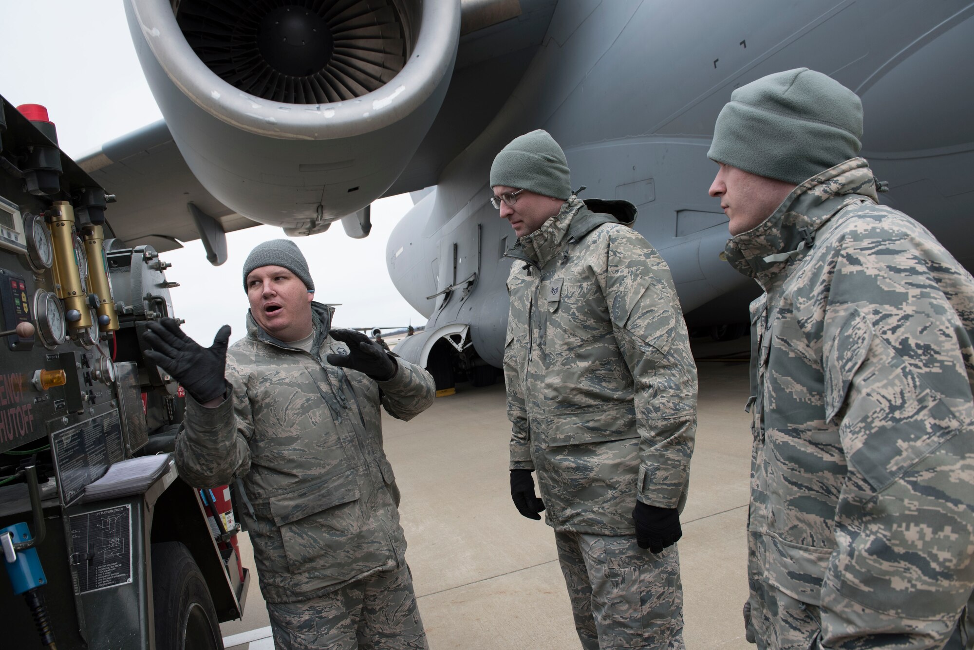 Master Sgt. Raymond Franze, left, a fuels management specialist for the 167th Airlift Wing, explains how to use a fueling truck at the Martinsburg, W.Va. air base, to Staff Sgt. Ryan Harmon and Airman 1st Class Richard Ahart, both fuels specialists for the 130th Airlift Wing, April 7. The 167th and the 130th Logistics Readiness Squadrons swapped ten Airmen over the April unit training assembly to afford them new training opportunities. (U.S. Air National Guard photo by Senior Master Sgt. Emily Beightol-Deyerle)