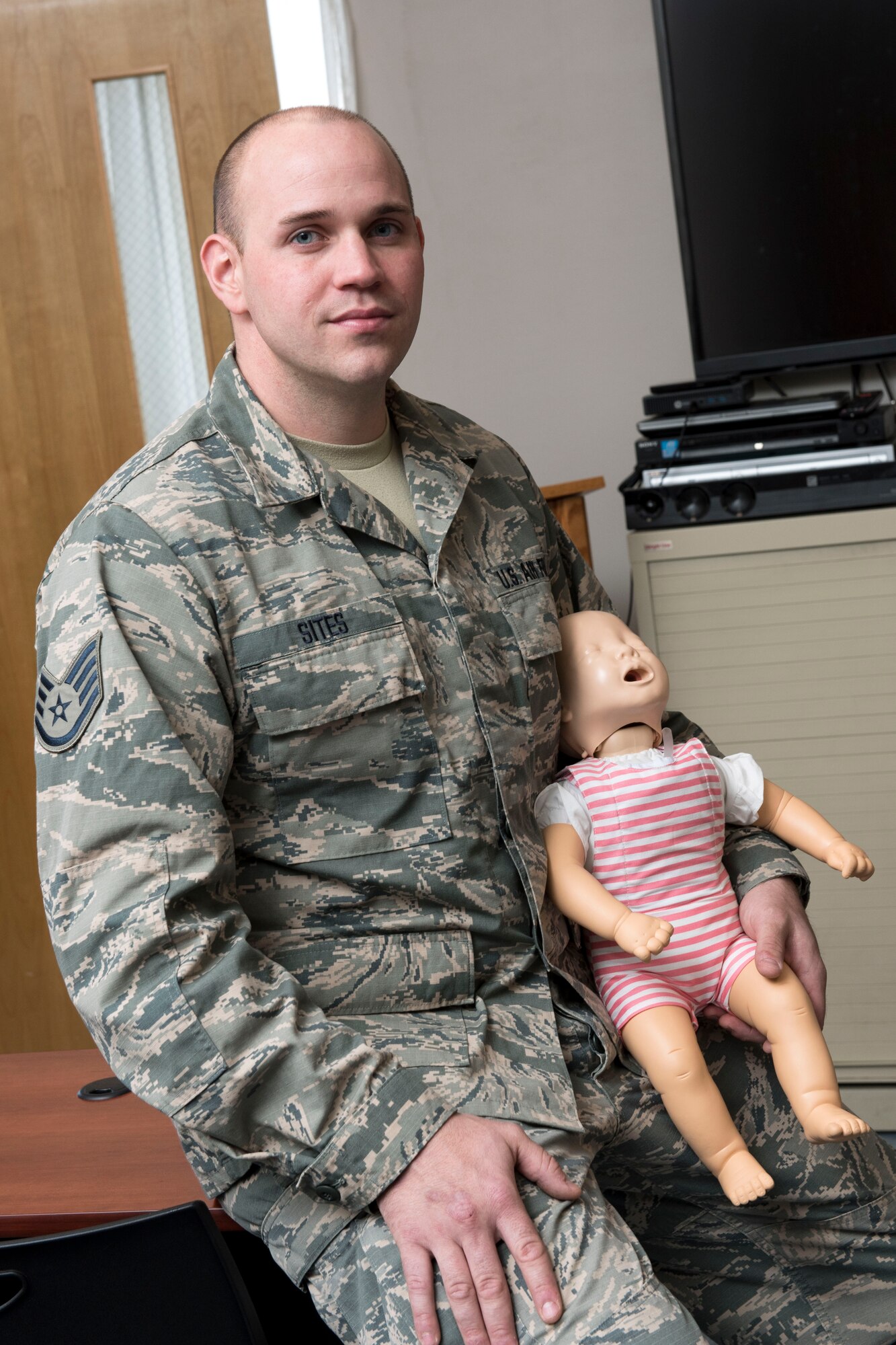 Staff Sgt. Travis Sites, an aerospace medical services technician for the 167th Medical Group, holds an infant mannequin used during the Basic Lifesaver Course that he teaches to members of the 167th Airlift Wing. (U.S. Air National Guard photo by Senior Master Sgt. Emily Beightol-Deyerle)