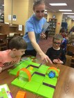 Olga Oakley shows children how to use Colby, the robotic coding mouse, during a program at the Coffee County Library. The Hands-On Science Center Board of Directors recently hired Oakley to direct the Arnold Air Force Base STEM program.