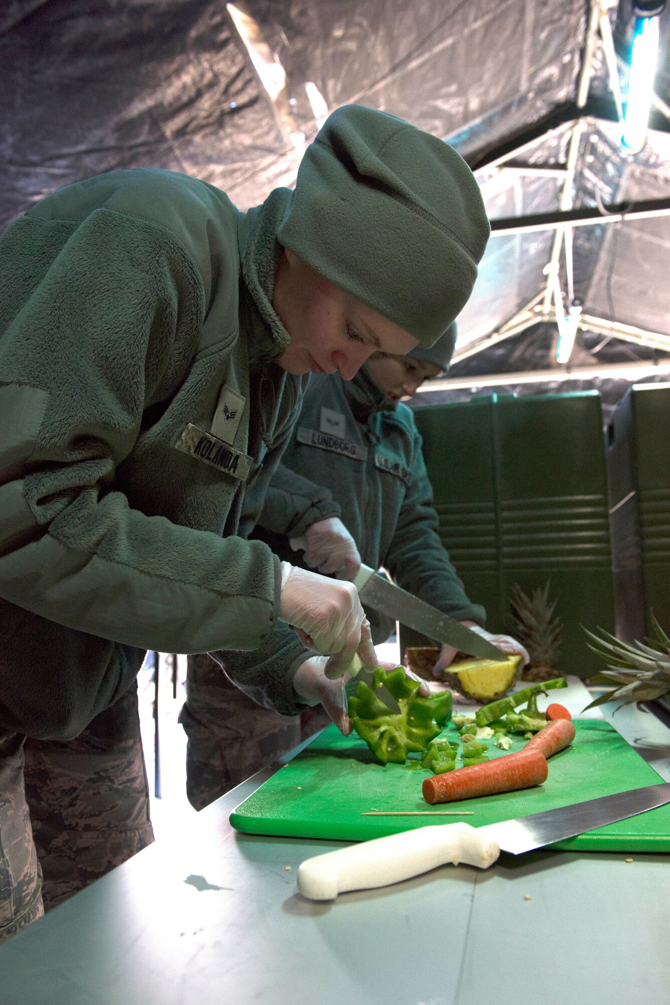 Senior Airmen Sarah Kolanda (left) and Madison Lundborg prepare fruits and vegetables at the SPEK kitchen during the April UTA. (Air Force Photo/Staff Sgt. Amber Jacobs)