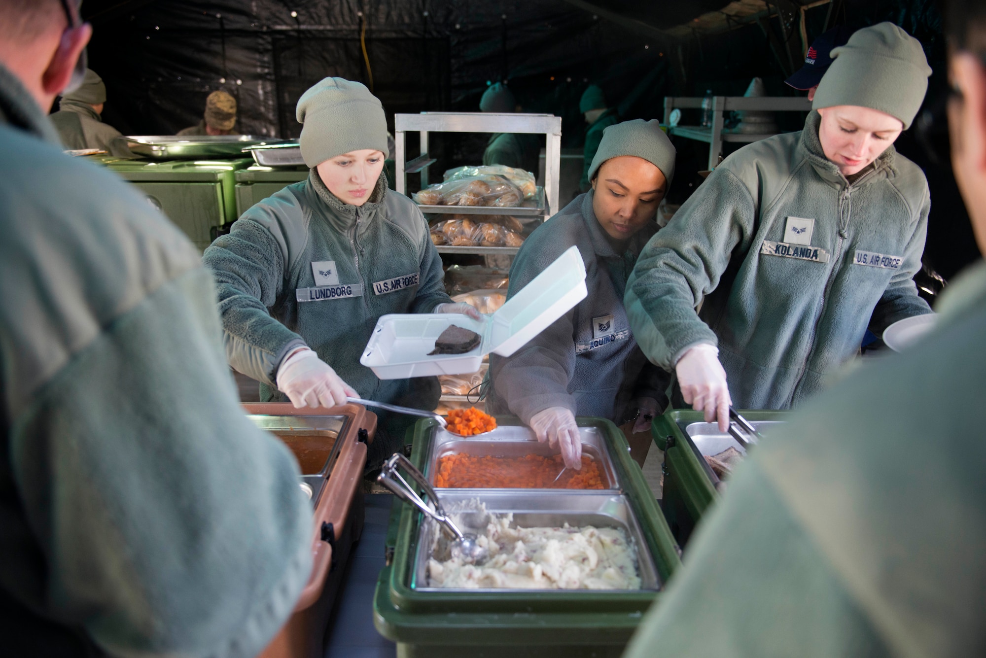 (L to R) Senior Airman Madison Lundborg, Tech. Sgt. Kimberlee Aquino and Senior Airman Sarah Kolanda serve lunch from the SPEK kitchen during the April UTA. (Air Force Photo/Tech. Sgt. Trevor Saylor)