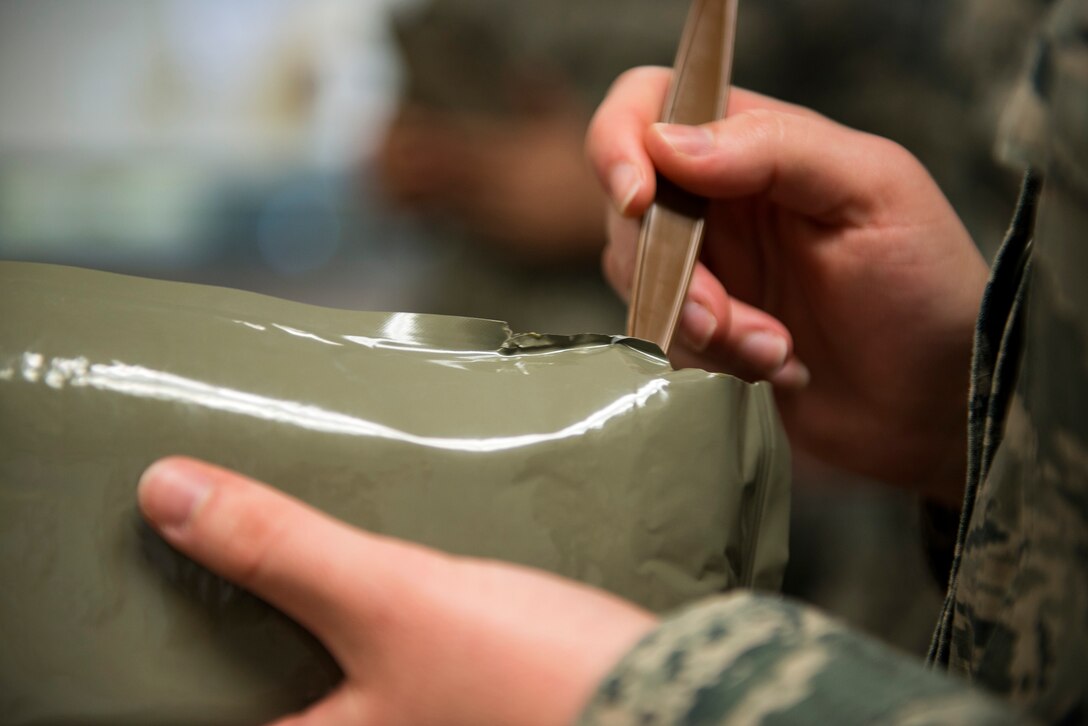 Airman McKenzie Daigle, 23d Aerospace Medicine Squadron public health technician, gets ready to eat a spoonful of her meal, ready to eat (MRE) during an MRE open-package inspection, April 6, 2018, at Moody Air Force Base, Ga. Airmen from Public Health examine the MREs for defects and overall quality and determine whether they’ll be utilized here, at other bases or to condemn the batch. Public Health monitors more than 8,400 MREs yearly to ensure they are safe and fit for consumption, so as to maintain a healthy fighting force. (U.S. Air Force photo by Airman 1st Class Erick Requadt)