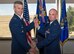 Col. Mark Stafford passes the 7th Space Operations Squadron guidon to Col. Stephen Slade, 310th Operations Group commander, as he relinquishes command during the change of command ceremony on Sunday, Apr. 8th, 2018.