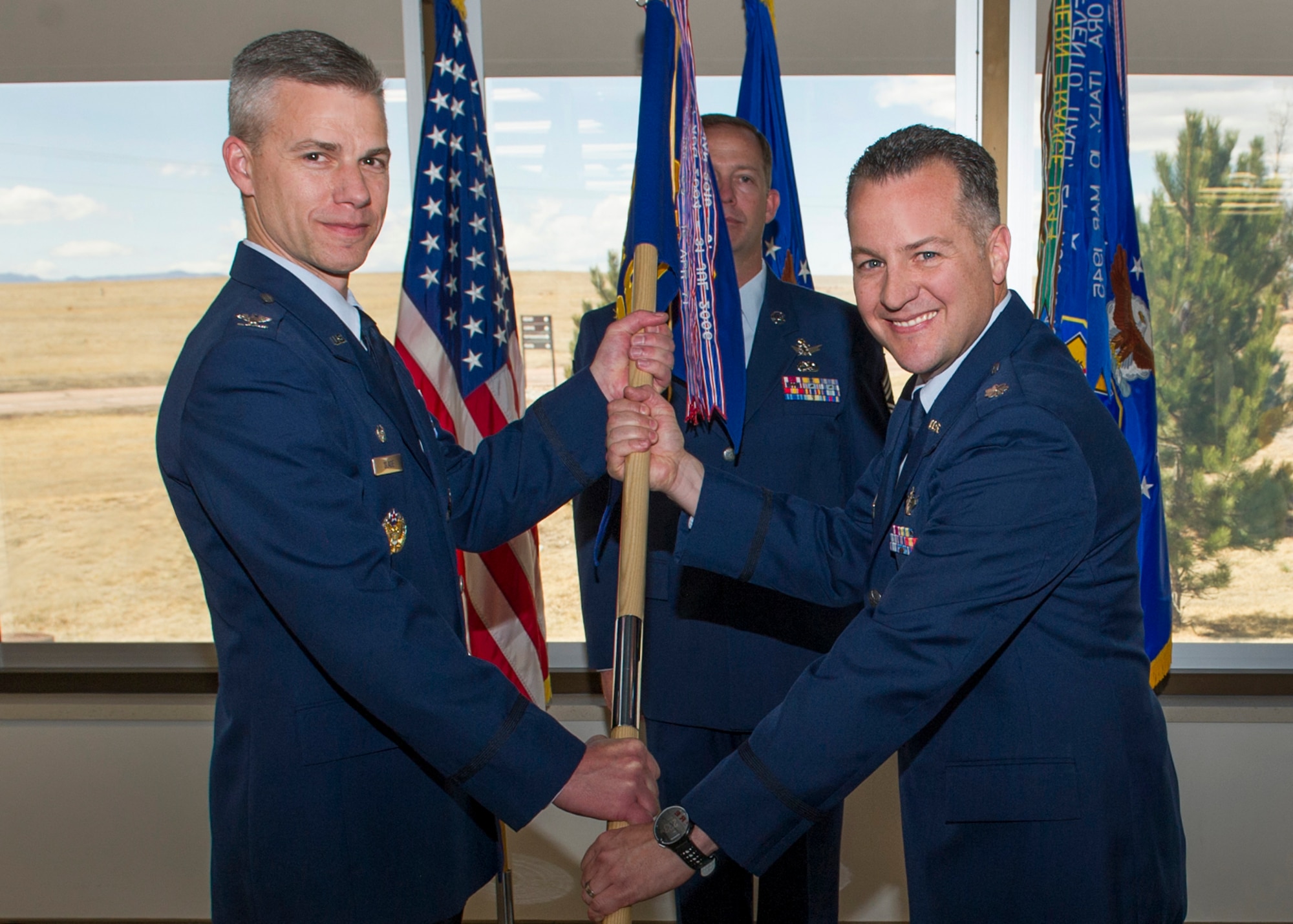 Lieutenant Col. James Hogan accepts the 7th Space Operations Squadron guidon from Col. Stephen Spade, 310th Operations Group commander, as he assumes command during the change of command ceremony on Sunday, Apr. 8th, 2018.