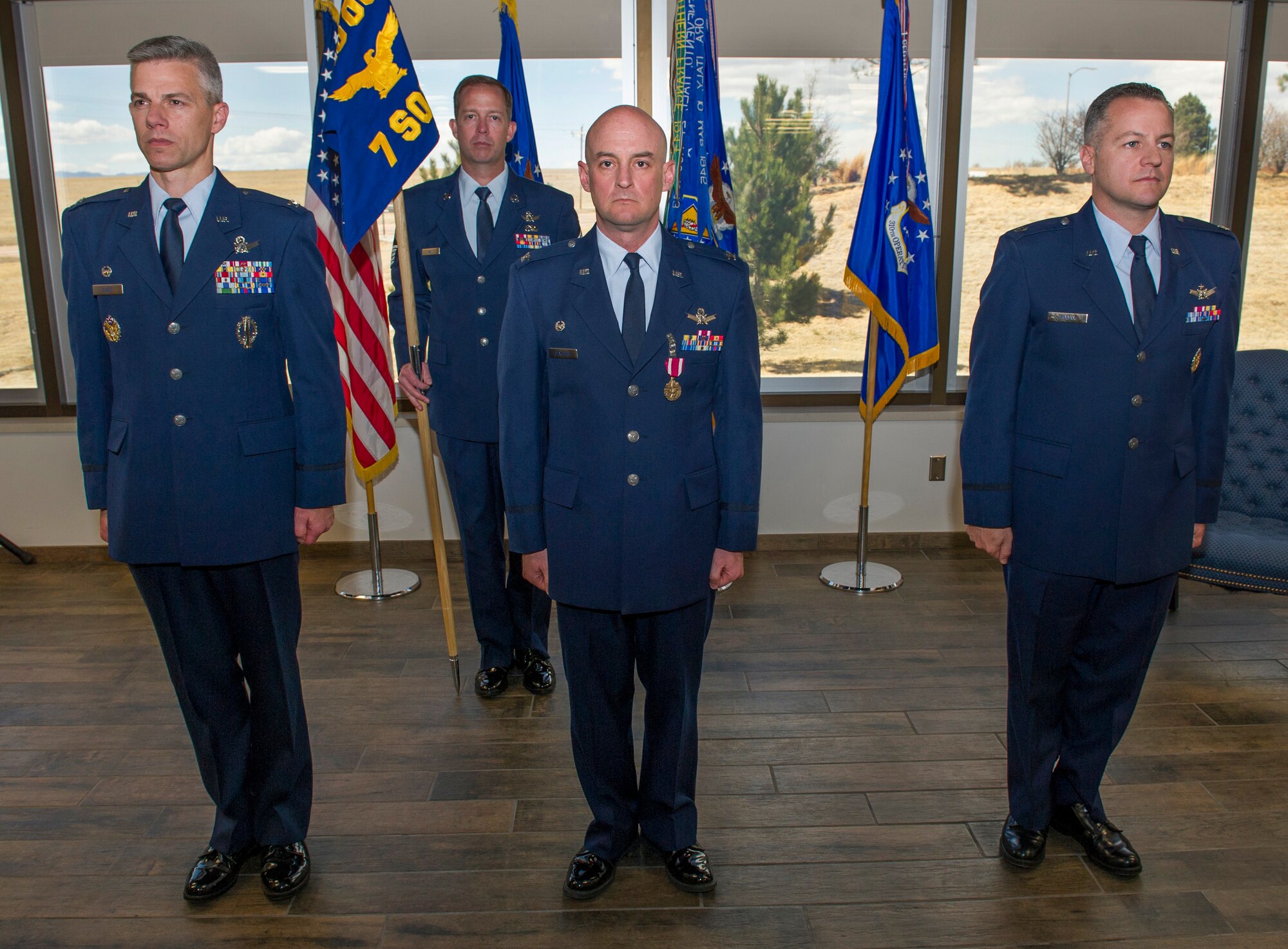 Col. Stephen Slade, 310th Operations Group commander, Col. Mark Stafford, outgoing 7th Space Operations Squadron commander, and Lieutenant Col. James Hogan, incoming 7 SOPS commander, stand at attention during the change of command ceremony on Sunday, Apr. 8th, 2018.