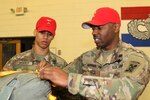 Army Sgt. Sean M. Bryant of Macon, Ga., shows Army Pvt. Joshua I. Brackin of Dothan, Ala., where the parachute static lines need to be checked for defects at Fort Valley, Ga.