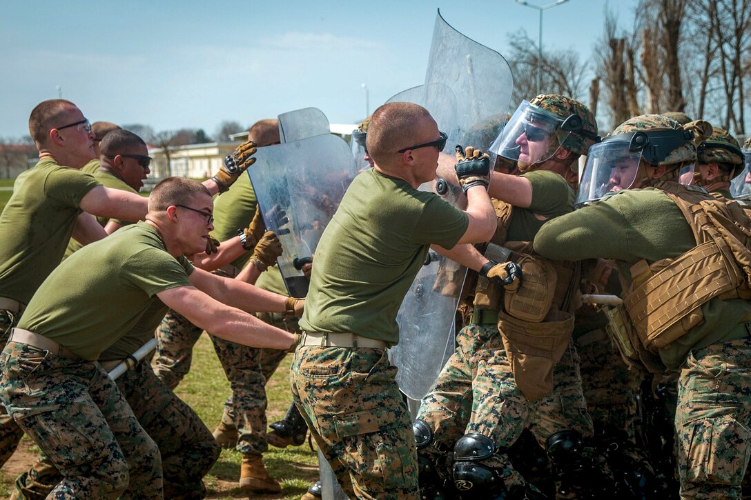 Marines with shields fight against other Marines.