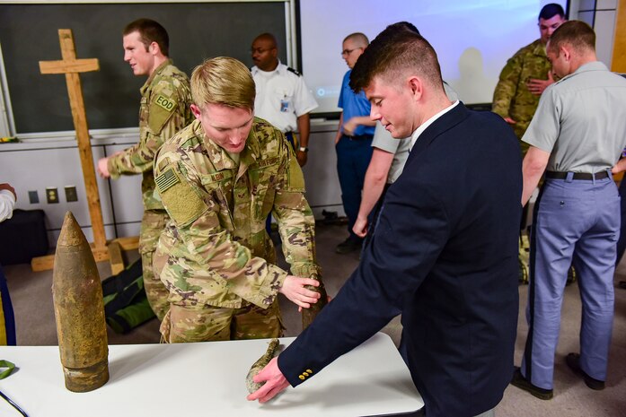 Senior Airman Jonathan Alvin, left, 628th Civil Engineer Squadron explosive ordnance disposal technician, describes different types of military ordnance to Cadet Kelbey Oakes, at The Citadel, April 3, 2018.