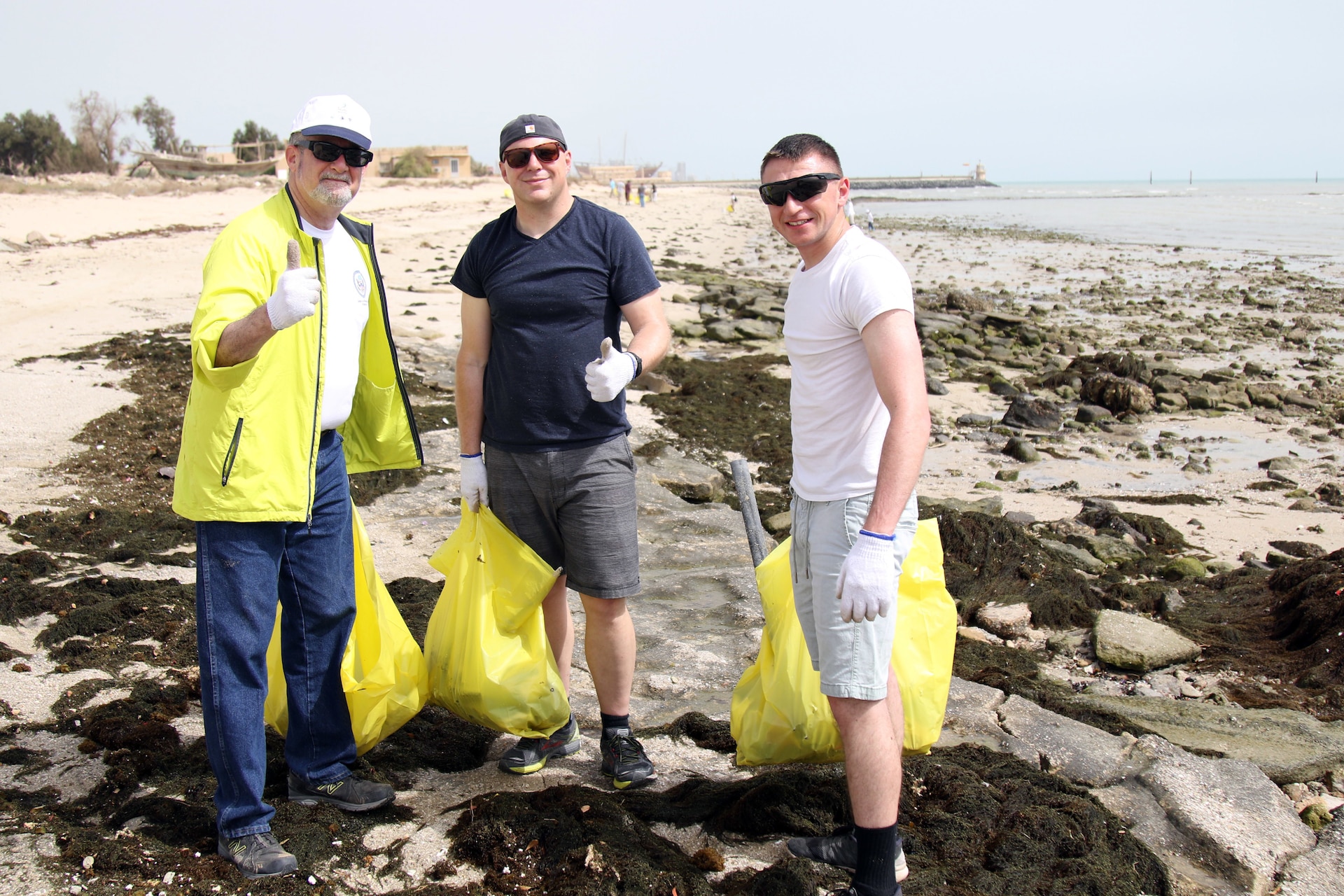 U.S. Ambassador to Kuwait Lawrence Silverman (left) pauses during a cleanup at Anjafa Beach for a photo with Pa. Army National Guard Soldiers Sgt. Timothy Reed (center) of Latrobe and Spc. Anthony Massaro of Philadelphia on April 7, 2018. Reed and Massaro are with Charlie Company, Headquarters and Headquarters Battalion, 28th Infantry Division and are deployed to Kuwait as part of Task Force Spartan. The event was the latest in an ongoing effort to rid Kuwait beaches of pollution.