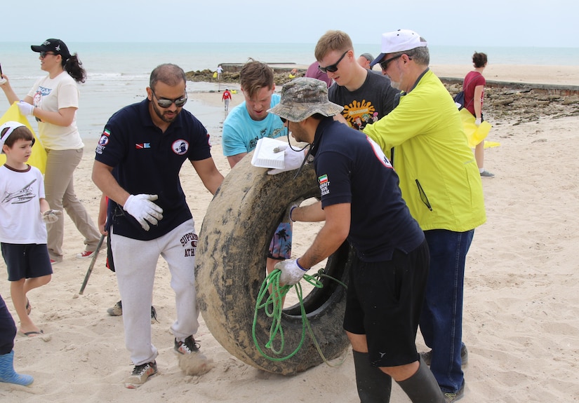 U.S. Ambassador to Kuwait Lawrence Silverman (right) and Kuwait Dive Team members Hamad Al-Fadhel (left), and Dr. Dari Al-Huwail join Spc. Dane Hill (second from left) and Spc. Sean Bower in removing a large tire from Anjafa Beach during a cleanup April 7, 2018. Hill, of Olyphant, Pa. and Bower, of East Strausburg, Pa. are Pa. Army National Guard Soldiers deployed to Kuwait with Bravo Company, Headquarters and Headquarters Battalion, 28th Infantry Division, Task Force Spartan.