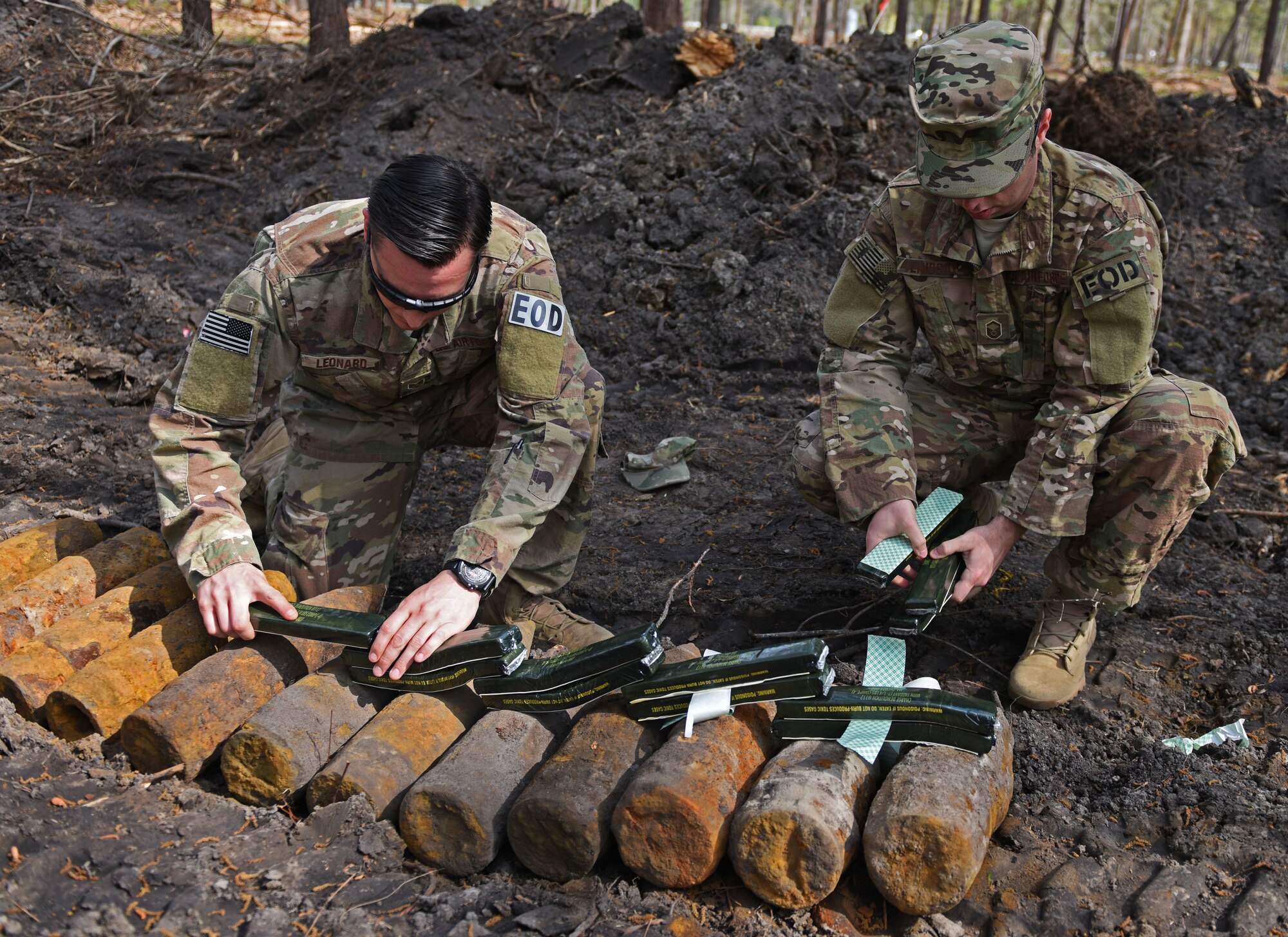 U.S. Air Force Staff Sgt. Benjamin Leonard, 20th Civil Engineering Squadron (CES) explosive ordinance disposal (EOD) journeyman, left, and Master Sgt. Nathanael Lindsay, 20th CES EOD flight chief, work together to place blocks of C4 explosives on top of unexploded ordinance (UXO) in Conway, S.C., April 4, 2018.