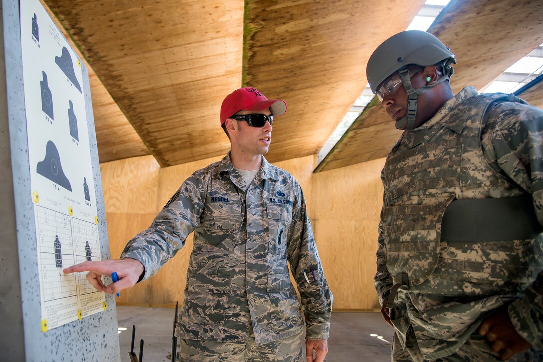 Staff Sgt. Brandon Nendel, left, 23d Security Forces Squadron Combat Arms Training and Maintenance (CATM) instructor, critiques the target sheet of Tech. Sgt. Jonathon Tyler, 23d Maintenance Group munitions specialist, during a CATM class, April 3, 2018, at Moody Air Force Base, Ga. Airmen must demonstrate quality safety standards while handling and shooting their weapons proficiently in order to be eligible to deploy. Throughout the class the instructors emphasized: weapon handling techniques, proper sight usage and internal weapon cleaning procedures. (U.S. Air Force photo by Airman Eugene Oliver)