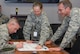 Col. Traci Kueker-Murphy, 310th Space Wing commander, and Lieutenant Col. Paxton Mellinger, 6th Space Operations Squadron commander, hold a celebratory "check" for Col. Stephen Slade, 310th Operations Group commander, to sign on Tuesday, Mar. 20, 2018.