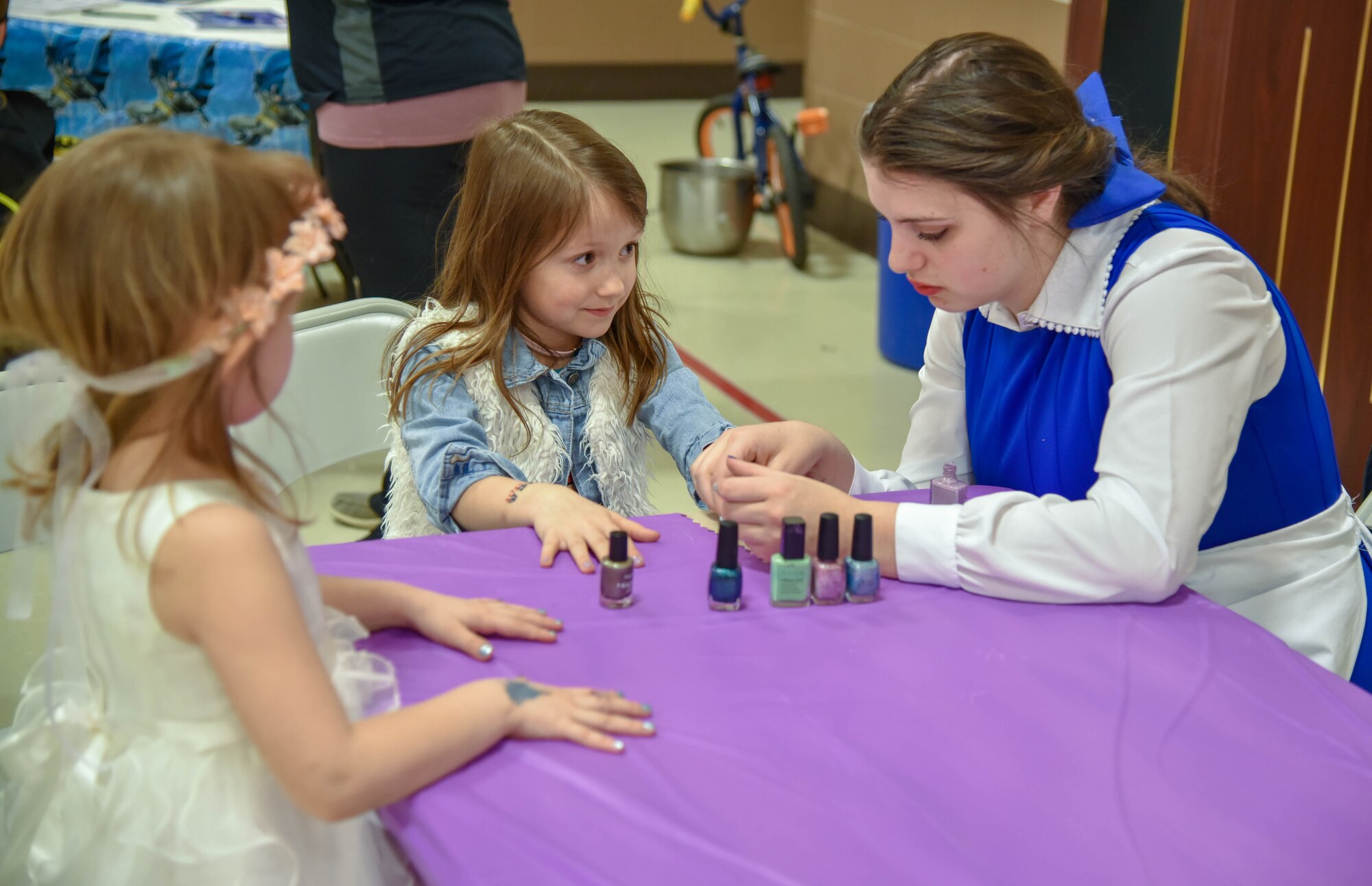 Addison and Baylee Johnson, daughters of 114th Fighter Wing members Master Sgt. Brian Johnson and Senior Master Sgt. Beth Johnson, gets their nails painted by Sophia Gapp, South Dakota National Guard Youth Council member, during the Princess and Super Hero Day Camp April 7, 2018, at the National Guard Armory, Sioux Falls, S.D.