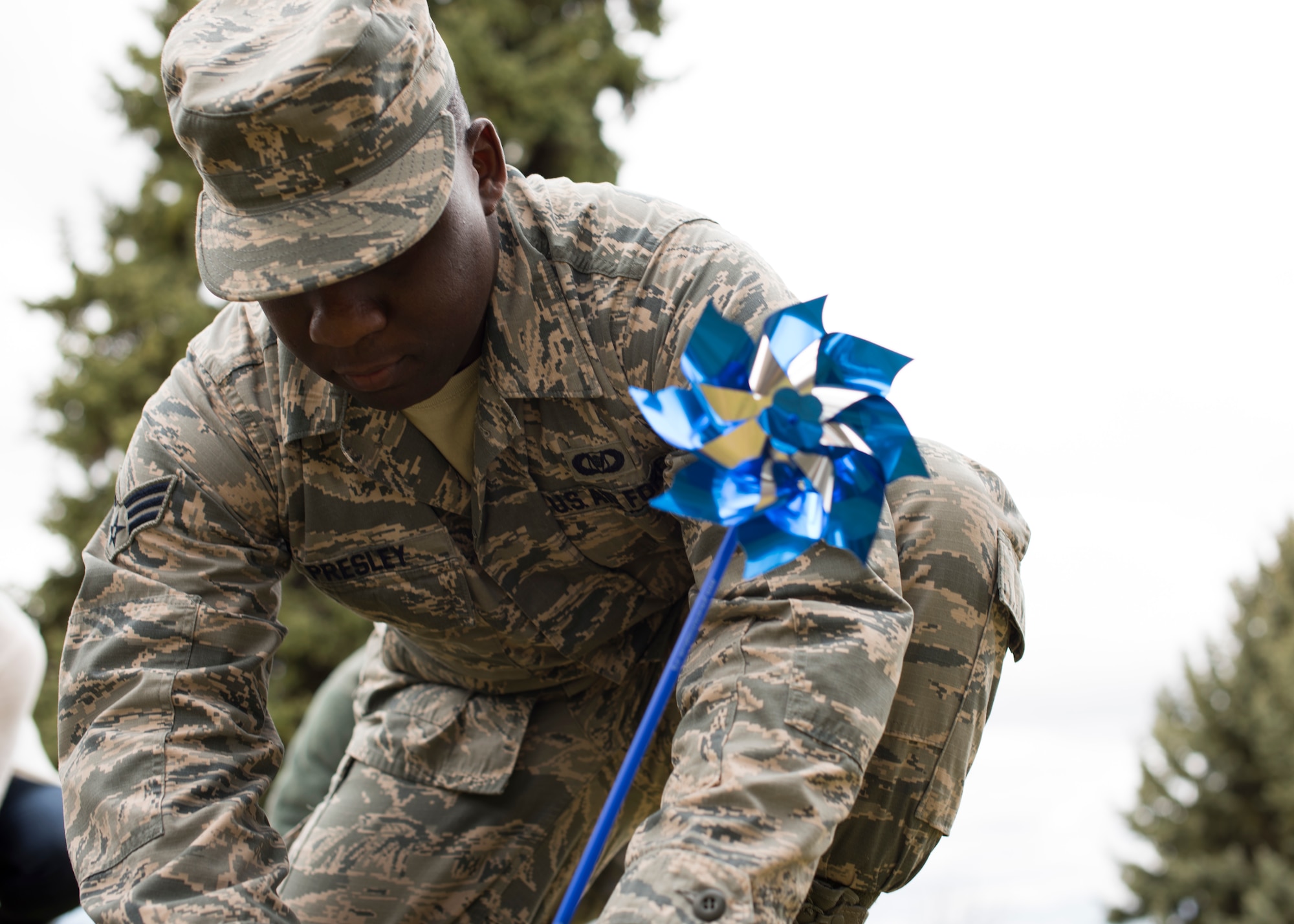 Senior Airman Davante Presley, 92nd Operation Support Squadron aviation resource manager, pins a pinwheel to the chapel lawn during a pinwheel ceremony in honor of Child Abuse Awareness Month at Fairchild Air Force Base, Washington, April 9, 2018. Research indicates children need a loving and supportive environment for a healthy childhood, a better chance of academic and financial success. (U.S. Air Force photo/Senior Airman Ryan Lackey)