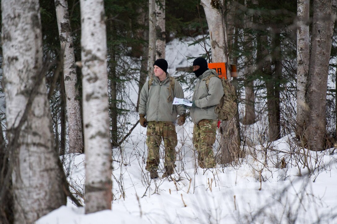 Soldiers maneuver through the woods to their next point.